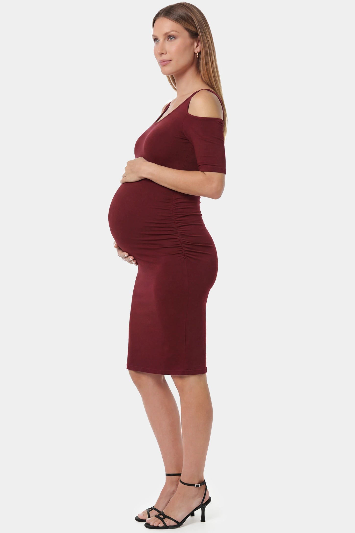Cold Shoulder Sleeve Fitted Short Maternity Dress Cold shoulder sleeve fitted short maternity dress in burgundy featuring soft stretch fabric in full body side view on a pregnant model