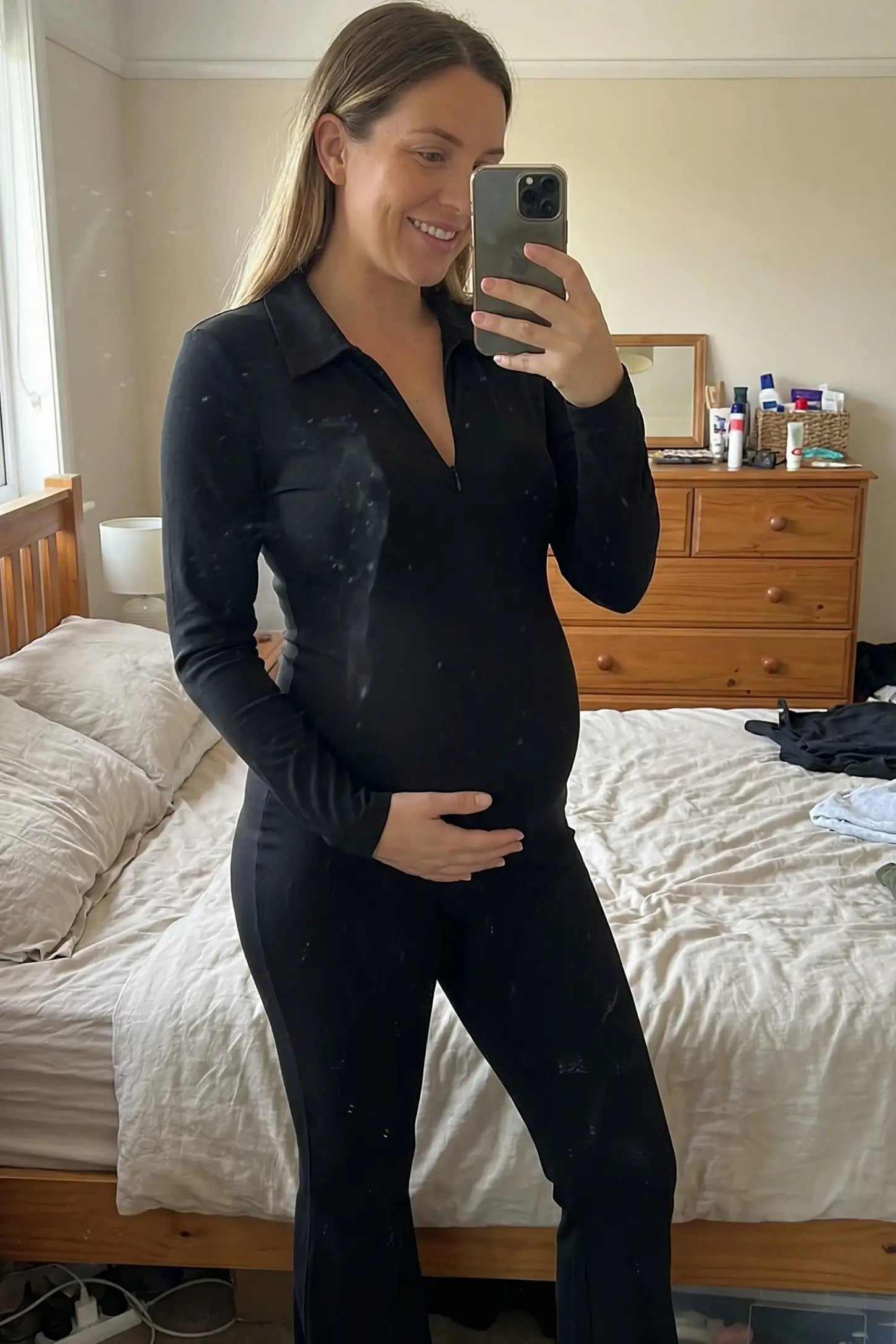 Collared Zip-Front Flared Maternity Jumpsuit Collared Zip-Front Flared Maternity Jumpsuit in Black featuring a figure shaping silhouette on a pregnant model.