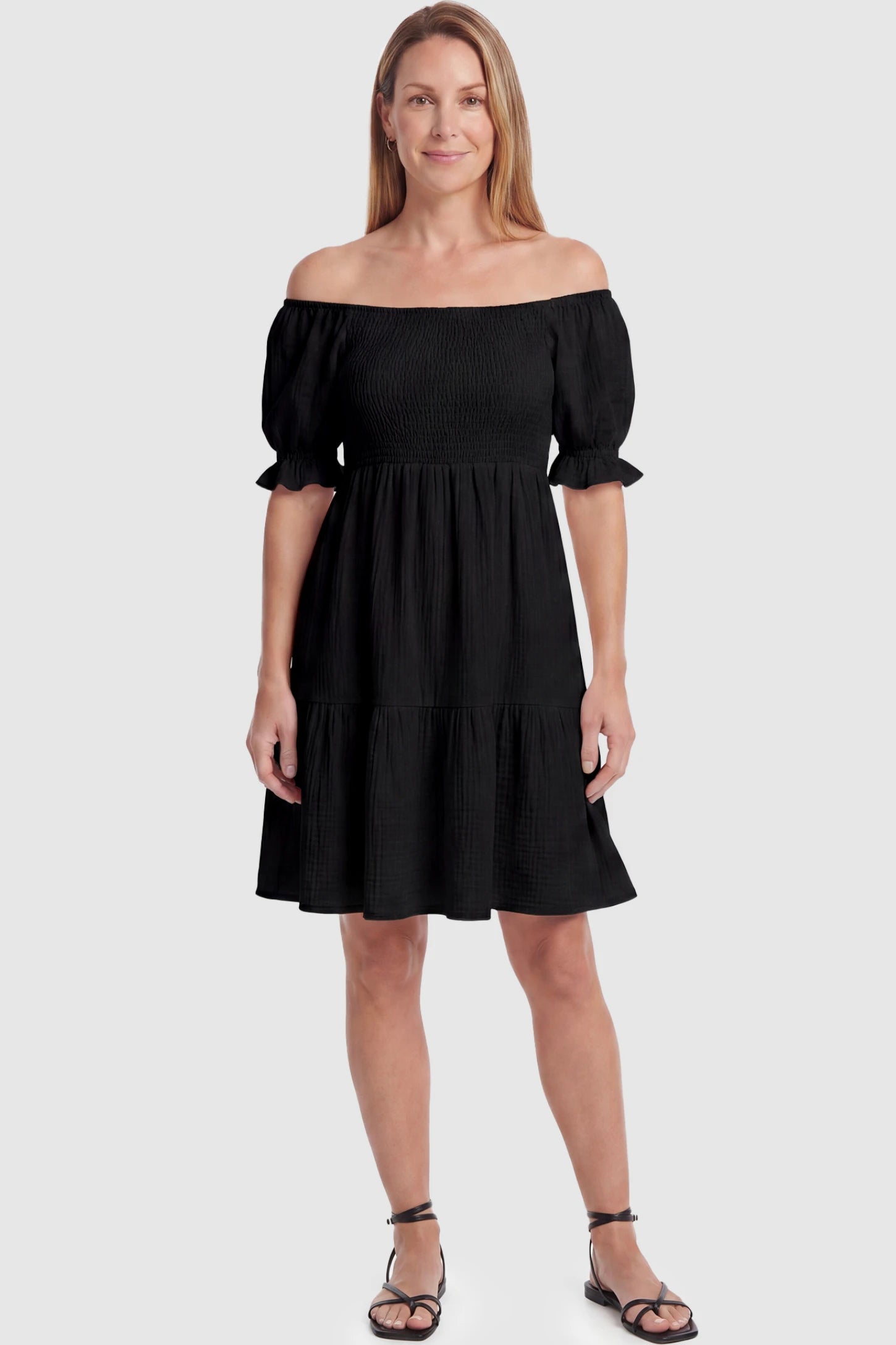 Smocked Off-Shoulder Empire Waist Maternity Short Dress Smocked off-shoulder empire waist maternity short dress in black with smocked bodice detail, front view on postpartum model