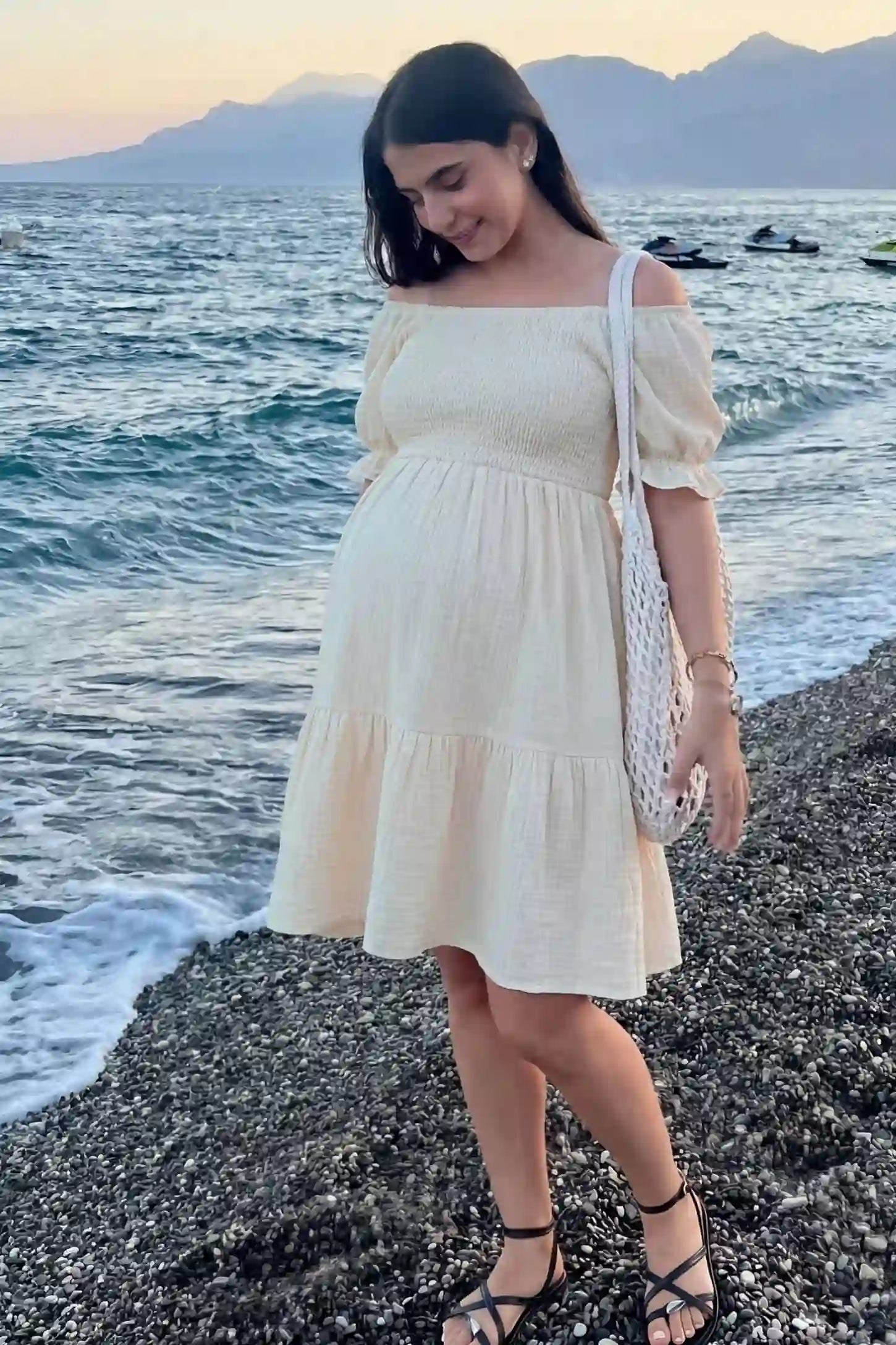 Smocked Off-Shoulder Empire Waist Maternity Short Dress Smocked off-shoulder empire waist maternity short dress in khaki with smocked bodice detail, front view on pregnant model