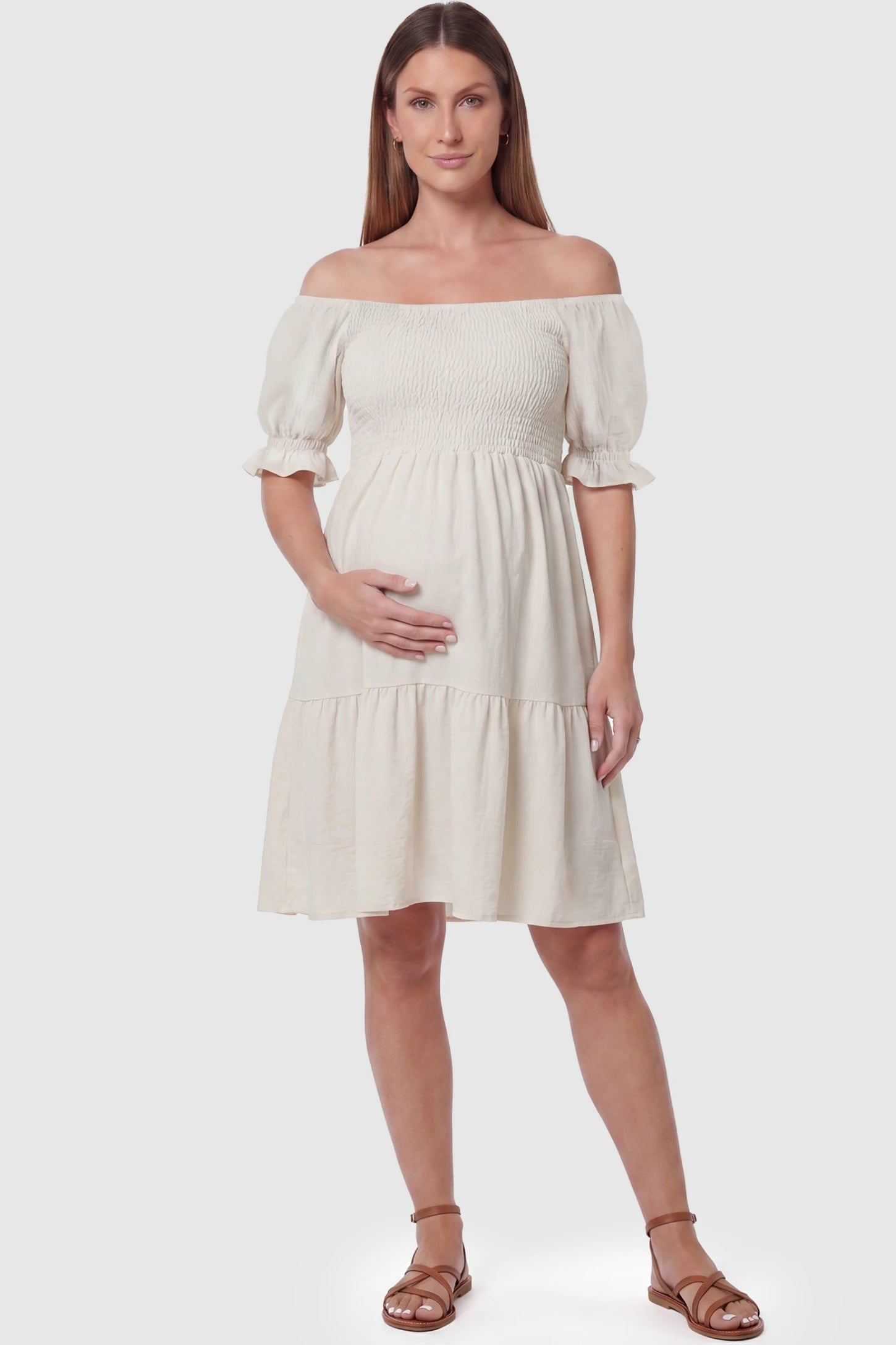 Smocked Off-Shoulder Empire Waist Maternity Short Dress Smocked off-shoulder empire waist maternity short dress in khaki with smocked bodice detail, front view on pregnant model