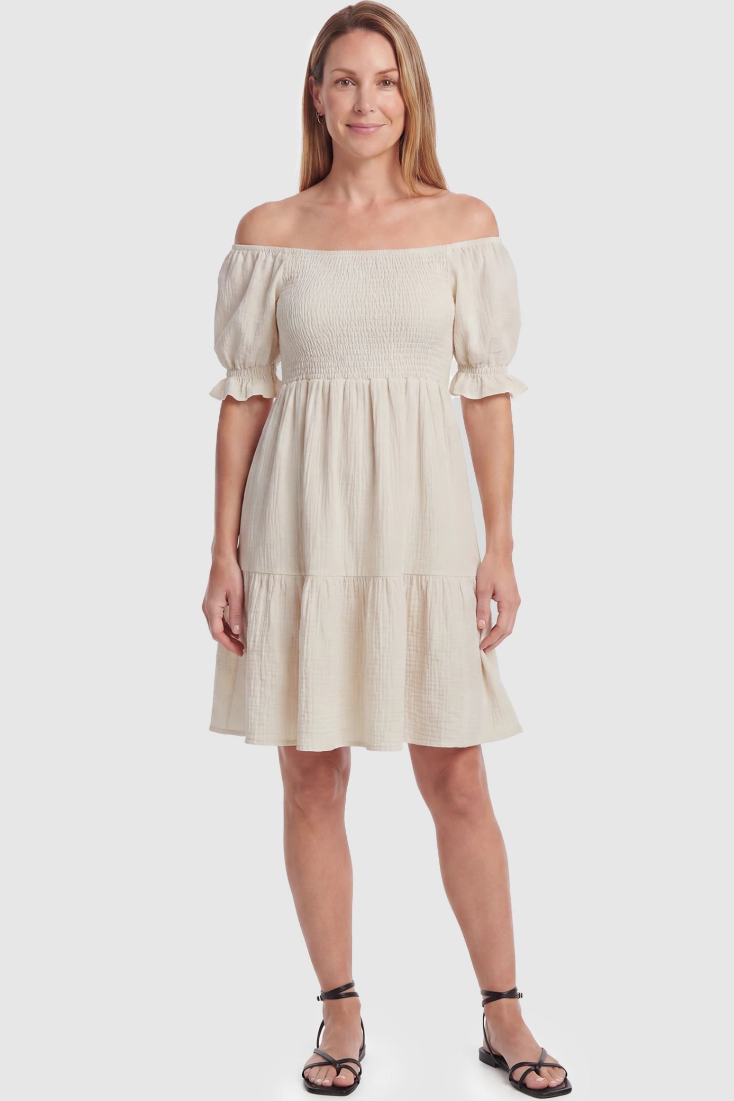 Smocked Off-Shoulder Empire Waist Maternity Short Dress Smocked off-shoulder empire waist maternity short dress in khaki with smocked bodice detail, front view on postpartum model