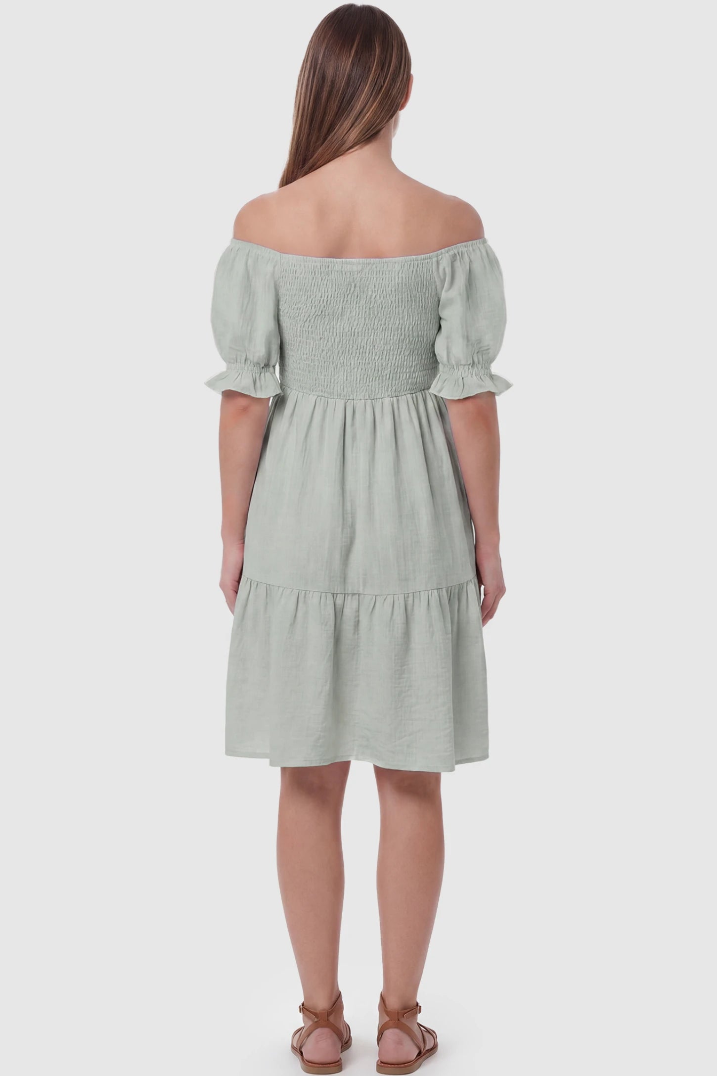 Smocked Off-Shoulder Empire Waist Maternity Short Dress Smocked off-shoulder empire waist maternity short dress in light green with short puff sleeve, back view on pregnant model