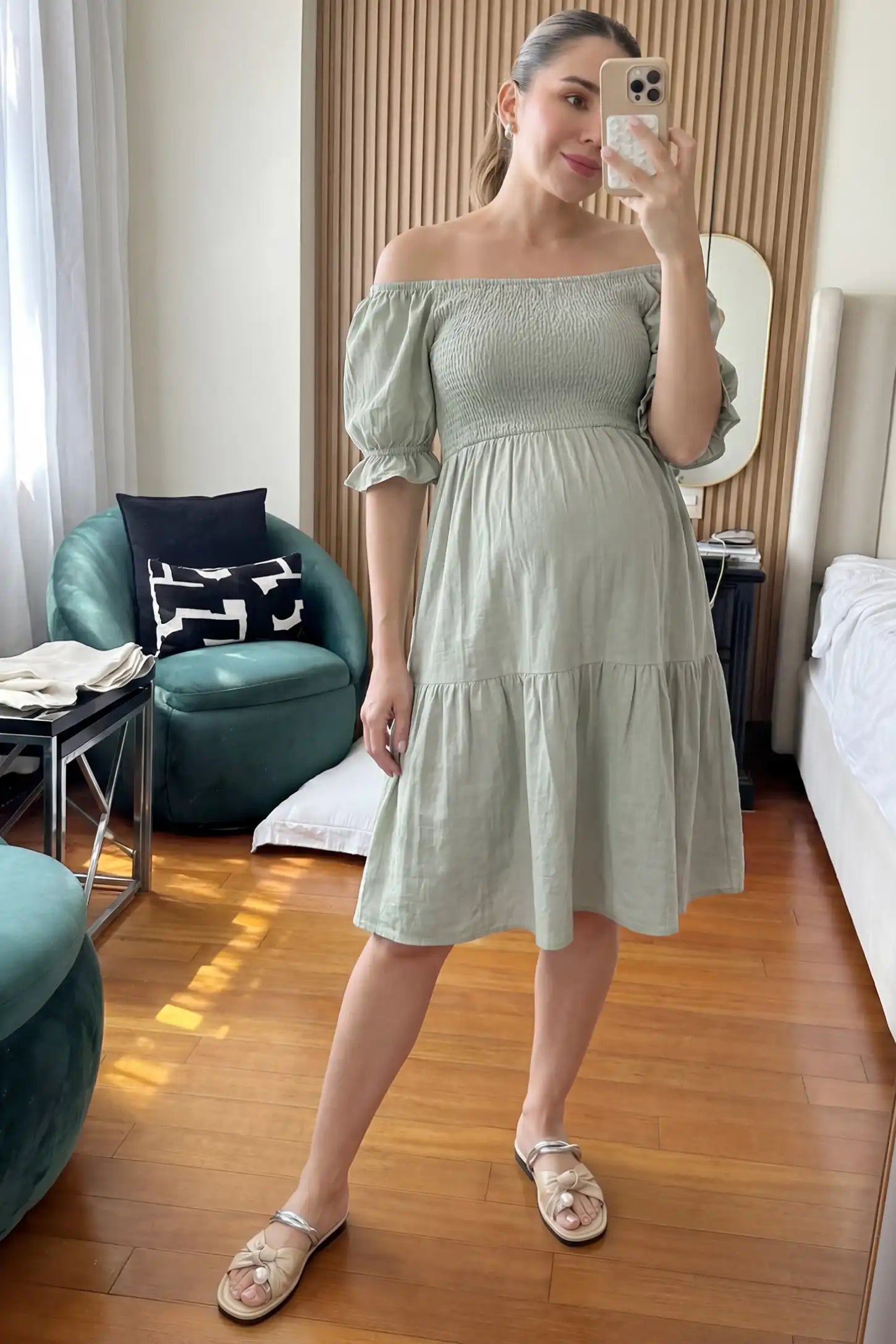 Smocked Off-Shoulder Empire Waist Maternity Short Dress Smocked off-shoulder empire waist maternity short dress in light green with smocked bodice detail, front view on pregnant model