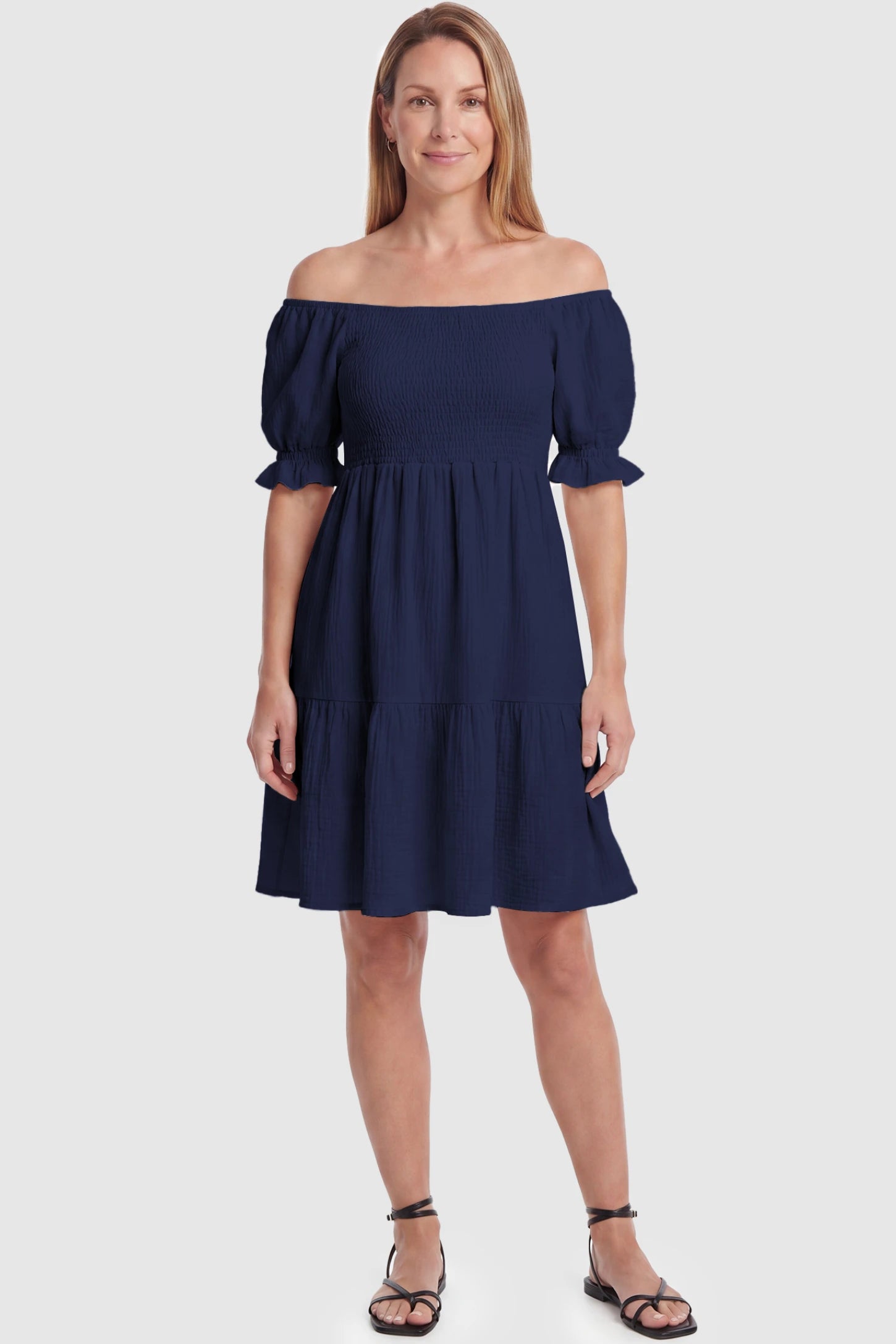 Smocked Off-Shoulder Empire Waist Maternity Short Dress Smocked off-shoulder empire waist maternity short dress in navy blue with smocked bodice detail, front view on postpartum model