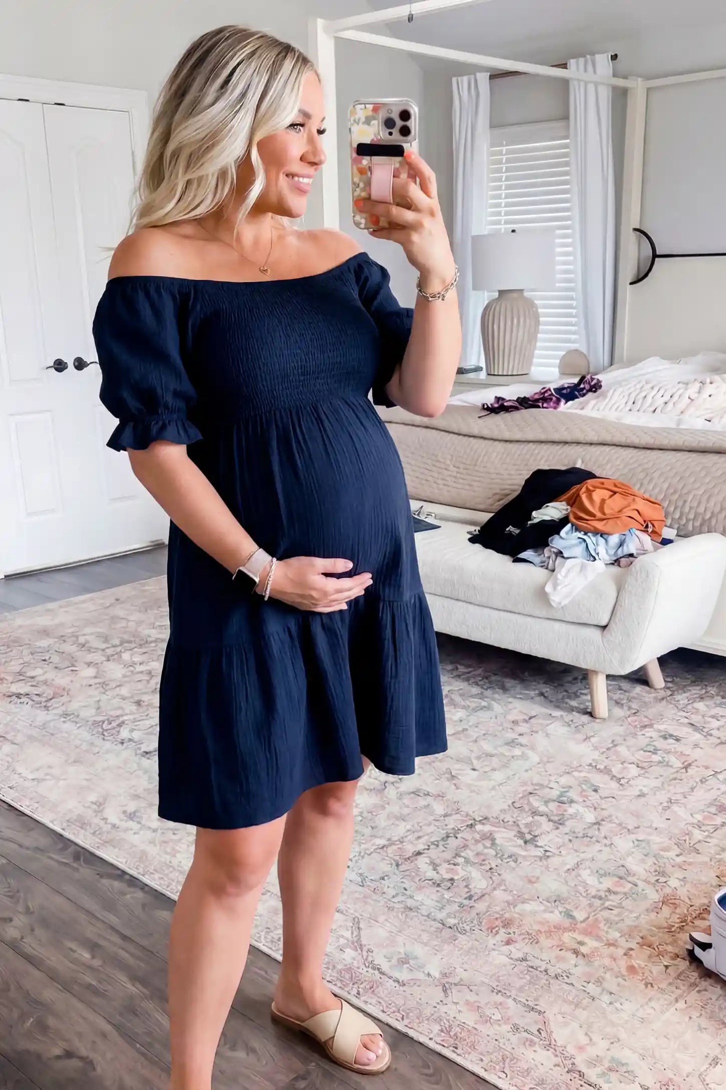 Smocked Off-Shoulder Empire Waist Maternity Short Dress Smocked off-shoulder empire waist maternity short dress in navy blue with smocked bodice detail, front view on pregnant model