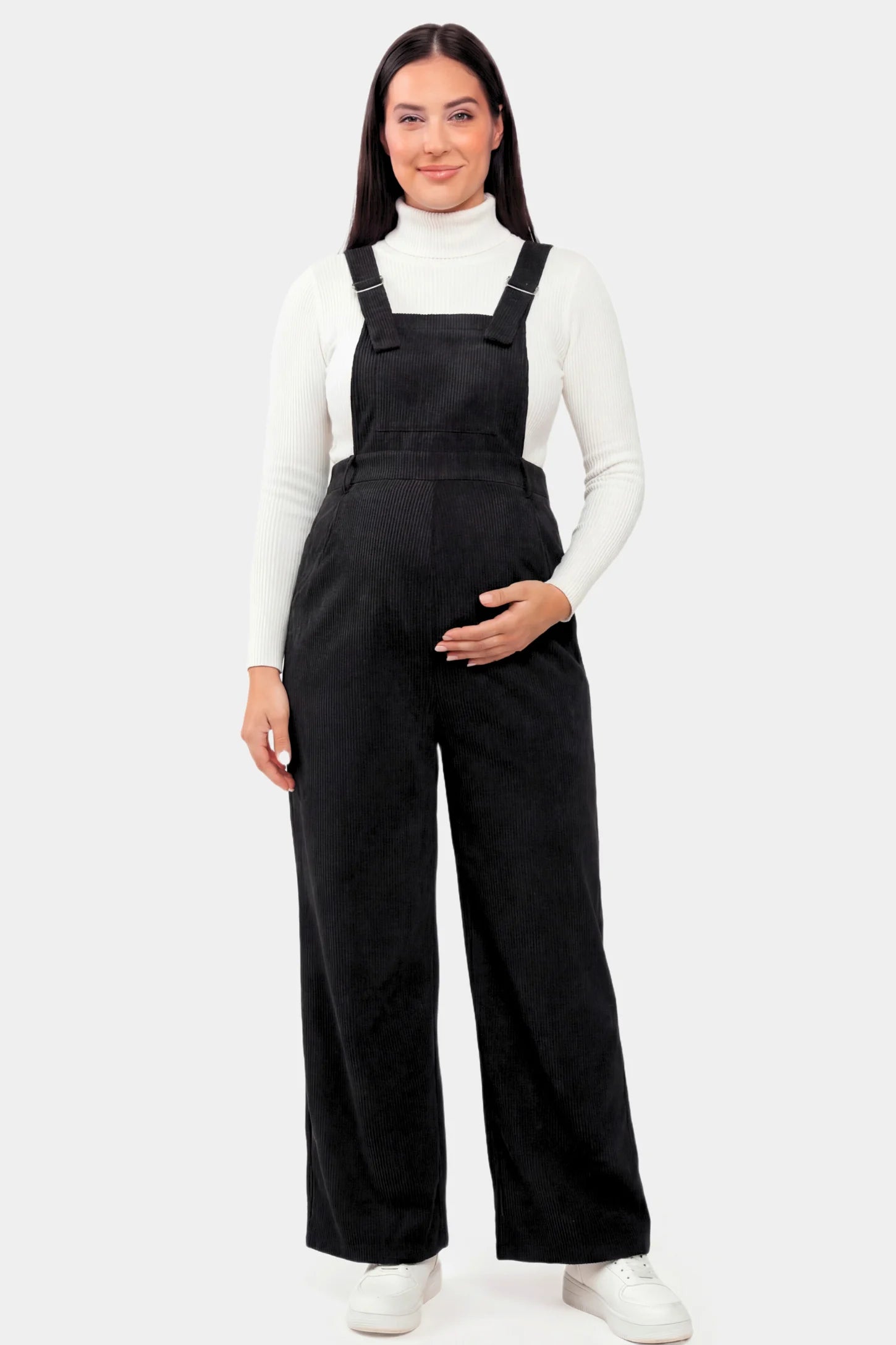 Corduroy Wide Leg Maternity Jumpsuit Corduroy Wide-Leg Maternity Jumpsuit in Black featuring a relaxed wide-leg silhouette on a pregnant model.