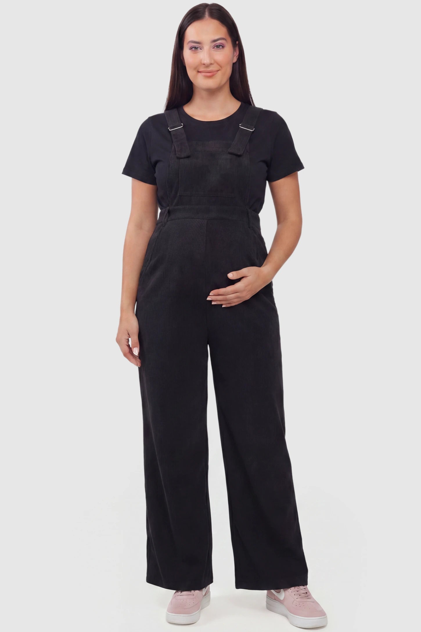 Corduroy Wide Leg Maternity Jumpsuit Corduroy Wide-Leg Maternity Jumpsuit in Black featuring a relaxed wide-leg silhouette on a plus size pregnant model, front view.