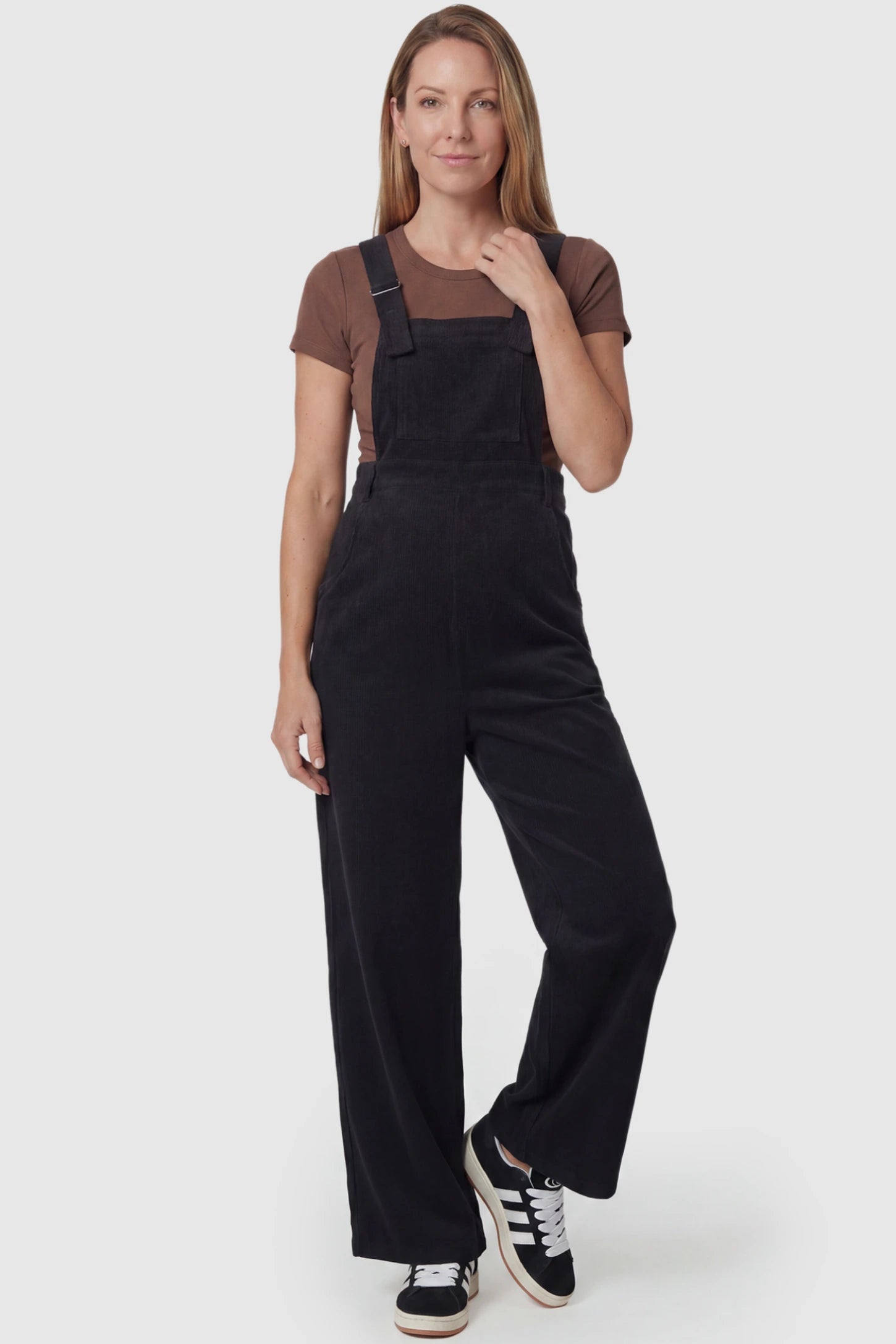 Corduroy Wide Leg Maternity Jumpsuit Corduroy Wide-Leg Maternity Jumpsuit in Black featuring a relaxed wide-leg silhouette on a postpartum model, front view.