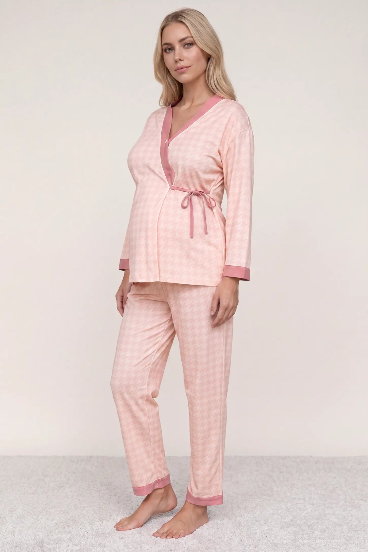 Cotton Houndstooth Nursing Pajama Set in Pink Houndstooth featuring a wrap V-neck top and full-length matching pants on a pregnant model, studio full-body front view.