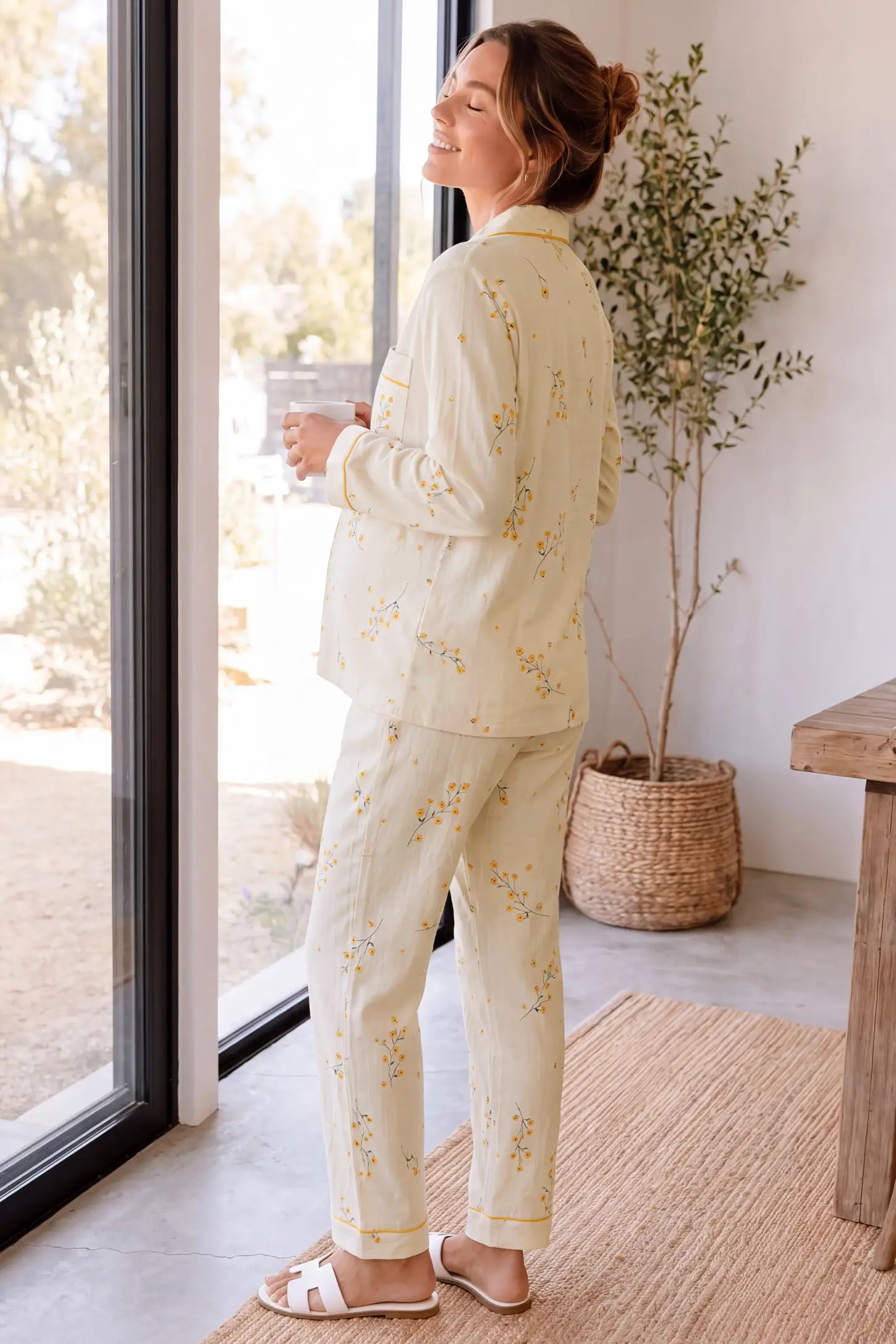 Cozy Floral Cotton Maternity Pajama Set Cozy Floral Cotton Maternity Pajama Set in Yellow Daisy featuring 100% breathable cotton fabric, long pants, and yellow piping accents on a pregnant model, standing near window view.