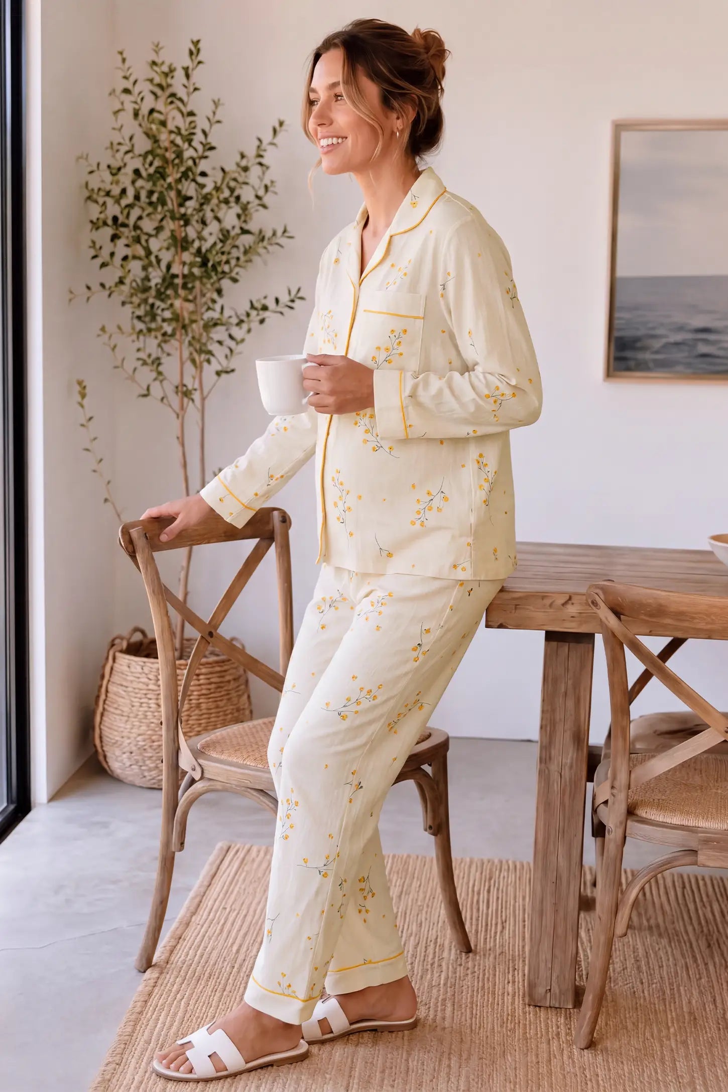Cozy Floral Cotton Maternity Pajama Set Cozy Floral Cotton Maternity Pajama Set in Yellow Daisy featuring button-front top, comfortable relaxed look, and soft yellow daisy floral print on a pregnant model, side standing view.