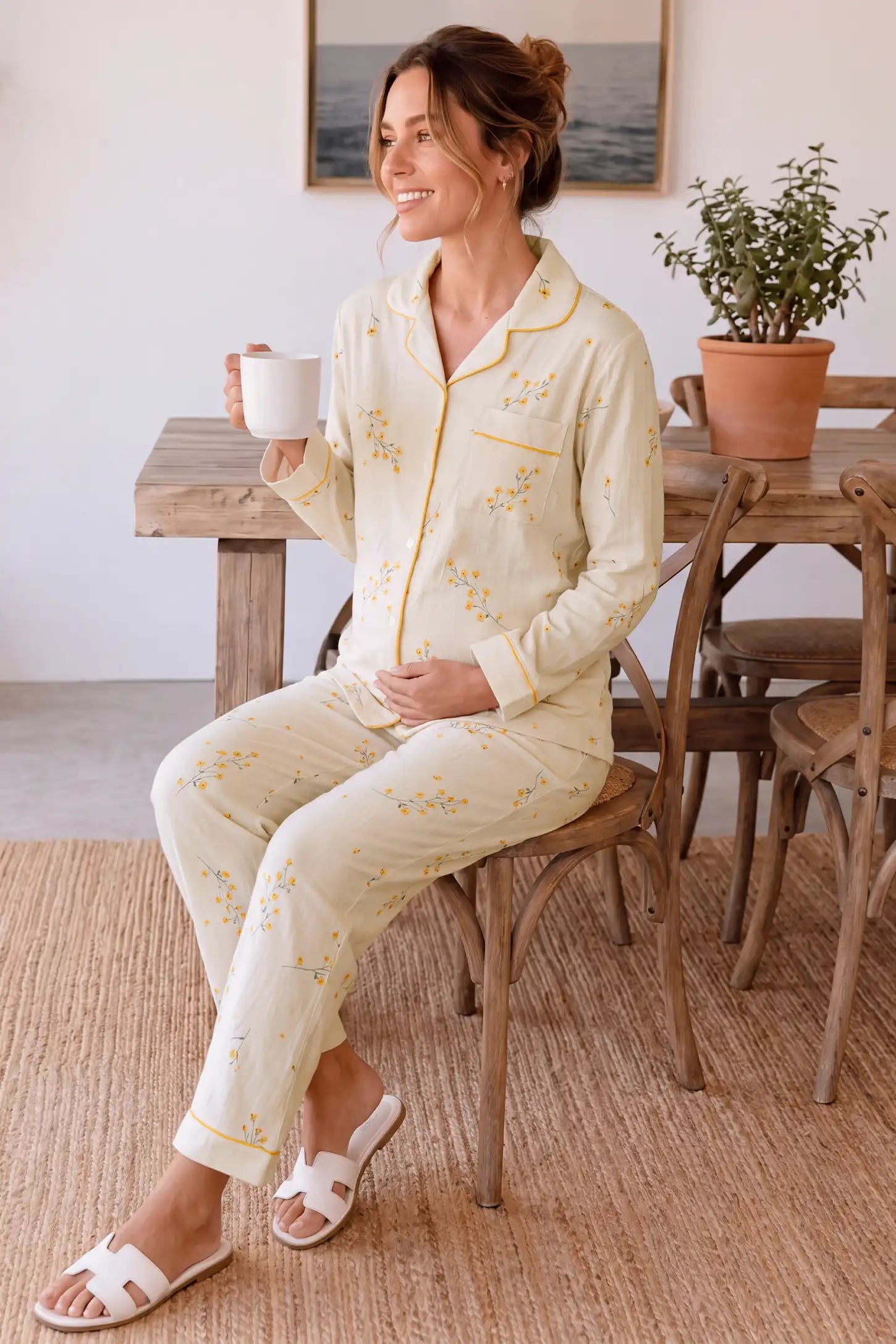 Cozy Floral Cotton Maternity Pajama Set Cozy Floral Cotton Maternity Pajama Set in Yellow Daisy featuring comfortable lounging fit, gentle bump support, and lightweight cotton material on a pregnant model, seated lounge view.