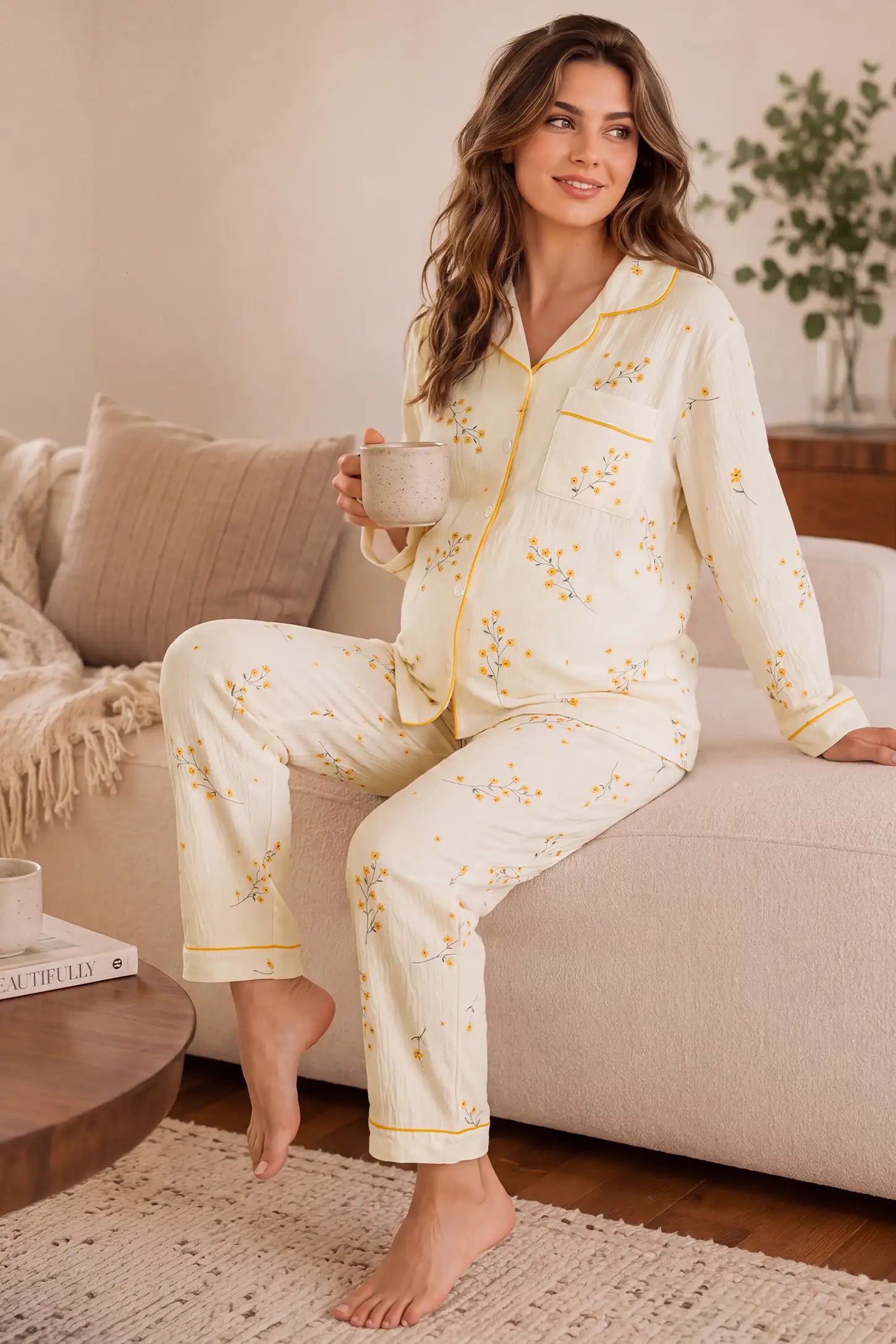 Cozy Floral Cotton Maternity Pajama Set Cozy Floral Cotton Maternity Pajama Set in Yellow Daisy featuring breathable 100% cotton fabric, yellow daisy graphics, and button-up front design on a pregnant model, couch lounge view.