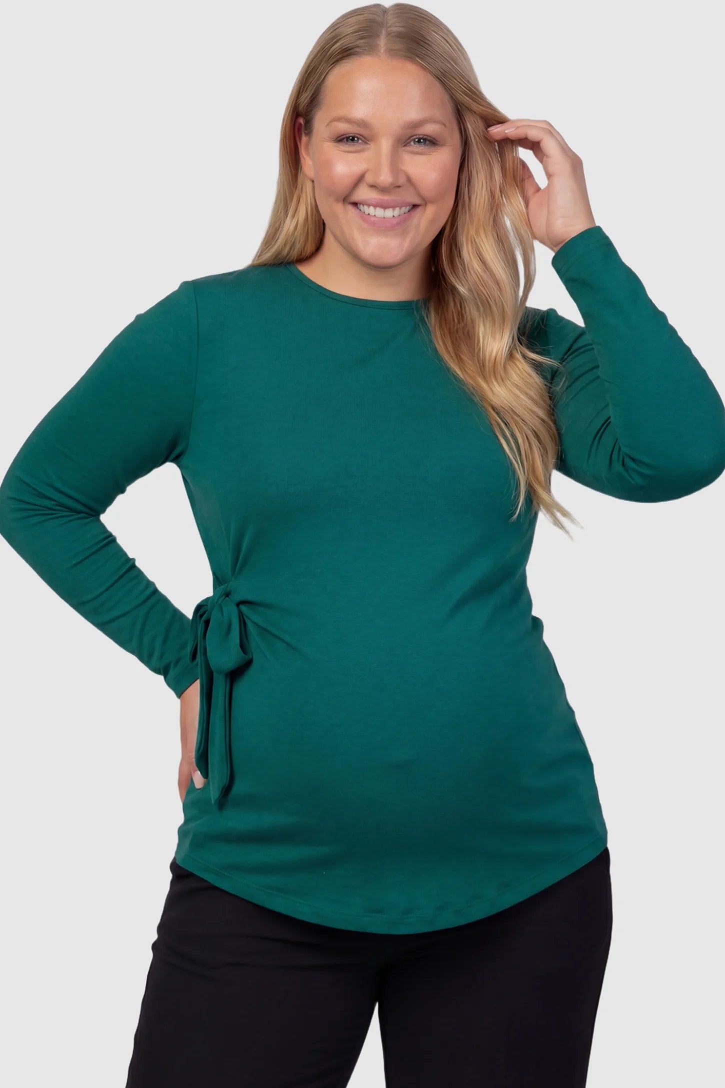 Crew Neck Long Sleeve with Side Tie Maternity Top Crew Neck Long Sleeve with Side Tie Maternity Top in green featuring an adjustable side tie and crew neckline on a plus size pregnant model front view.