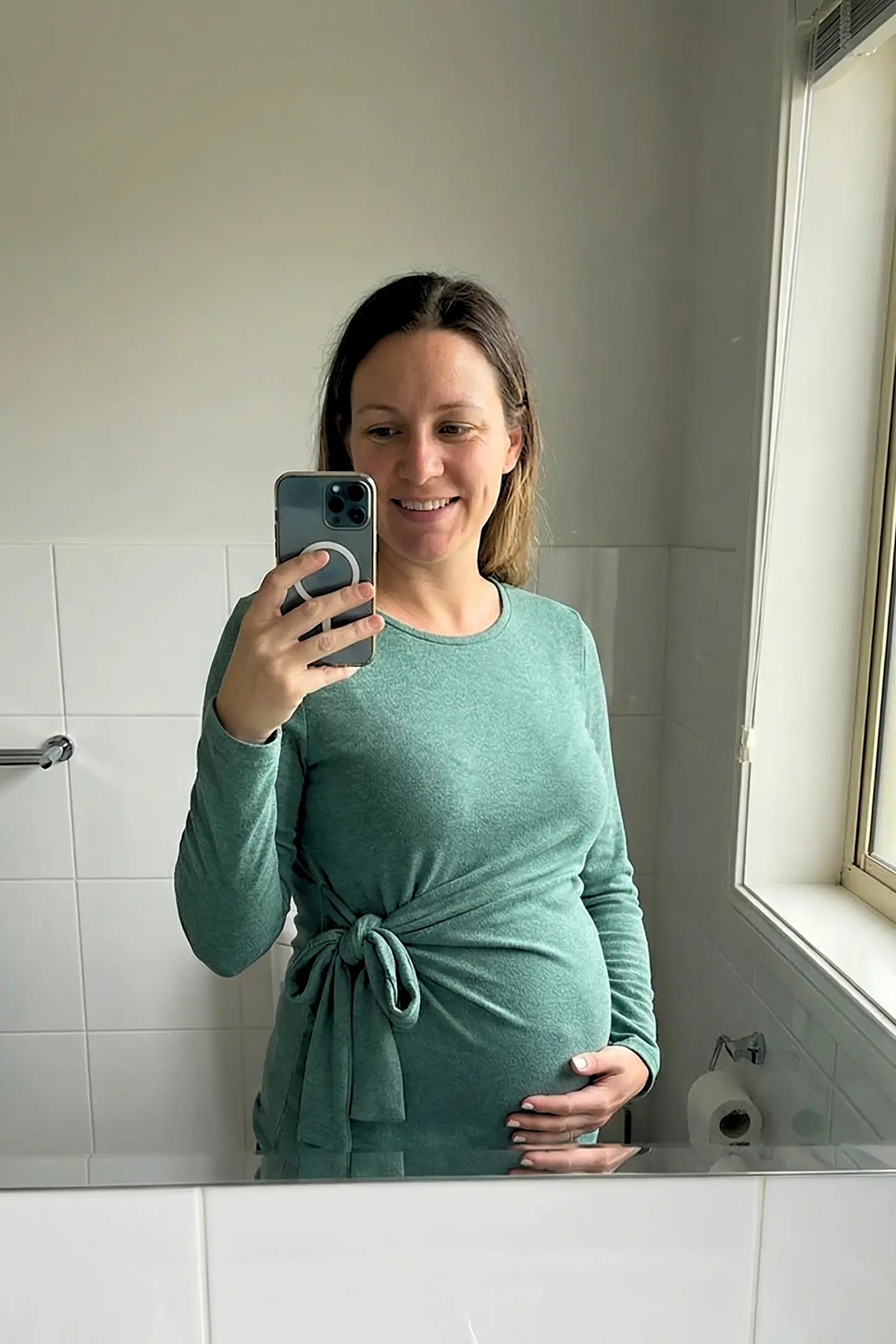 Crew Neck Long Sleeve with Side Tie Maternity Top Crew Neck Long Sleeve with Side Tie Maternity Top in green featuring an adjustable side tie and crew neckline on a pregnant model.