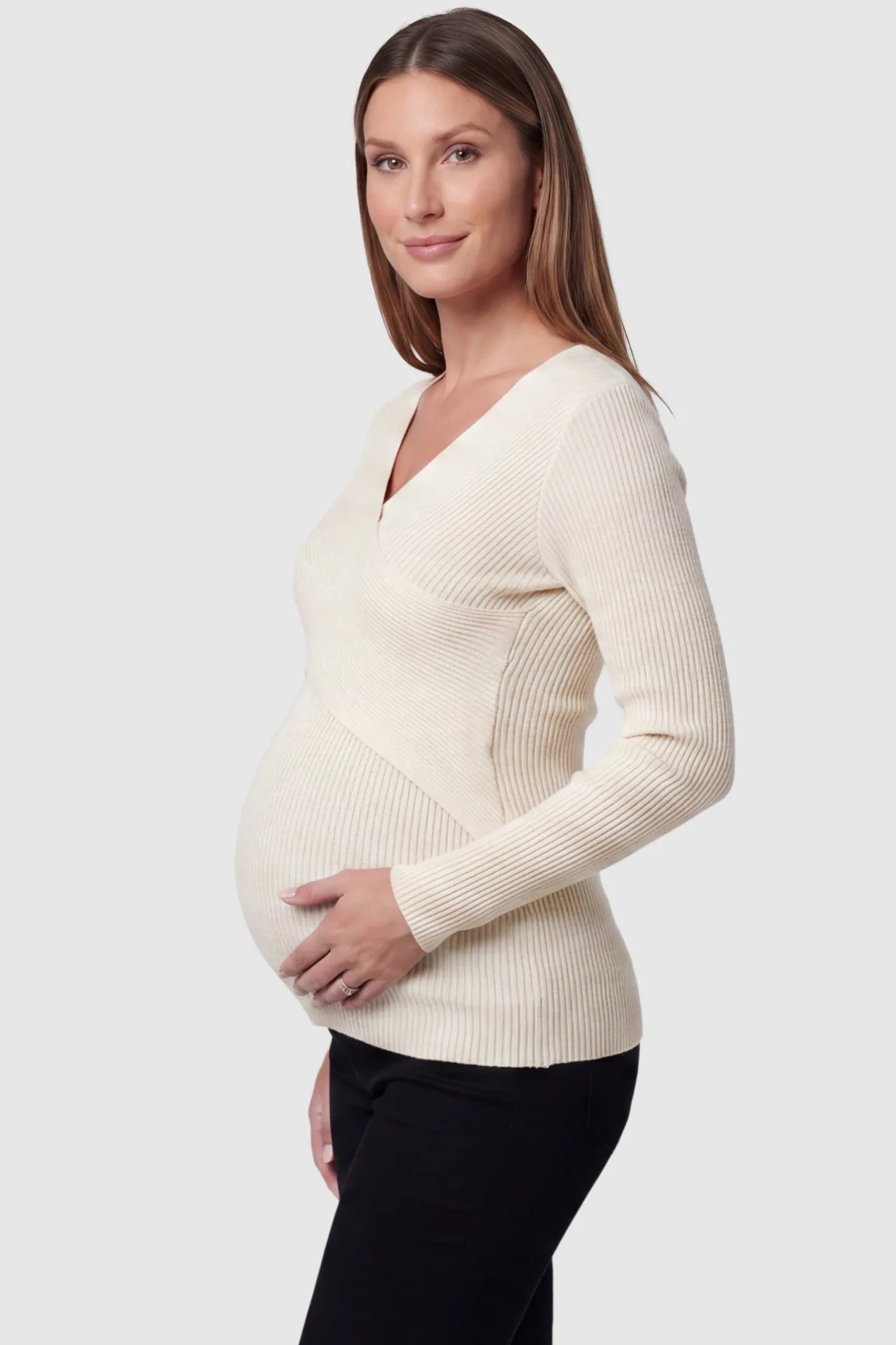 Cross-Over Ribbed Knit Maternity & Nursing Top Cross-Over Ribbed Knit Maternity & Nursing Top in Apricot featuring a wrap neckline and textured finish on a pregnant model, side view.