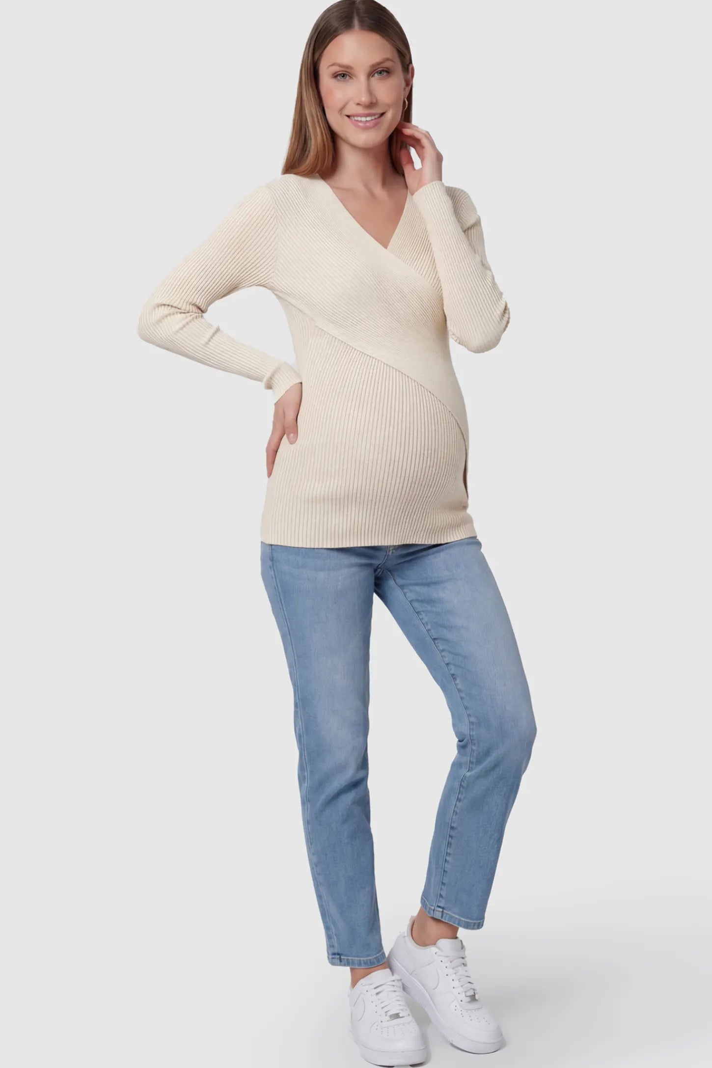 Cross-Over Ribbed Knit Maternity & Nursing Top Cross-Over Ribbed Knit Maternity & Nursing Top in Apricot featuring a wrap neckline and textured finish on a pregnant model, full body shot.