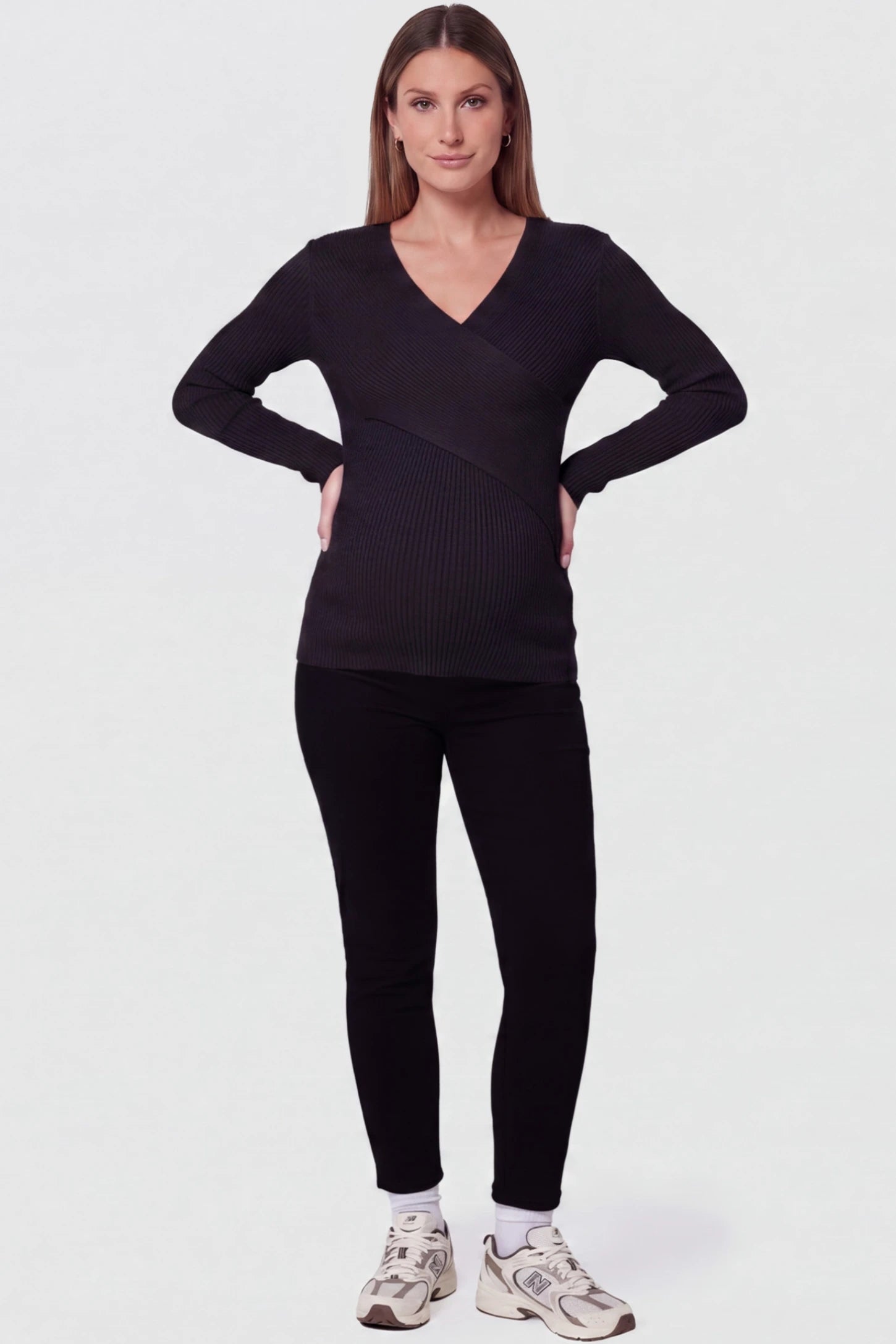Cross-Over Ribbed Knit Maternity & Nursing Top Cross-Over Ribbed Knit Maternity & Nursing Top in Black featuring a wrap neckline and textured finish on a pregnant model, full body view.
