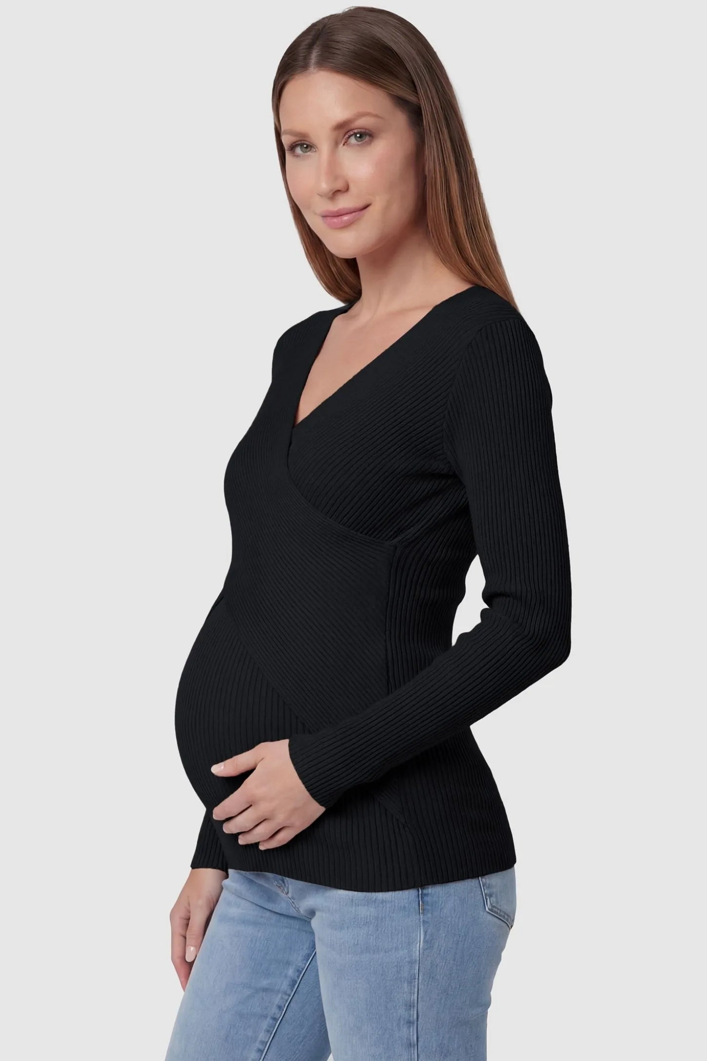 Cross-Over Ribbed Knit Maternity & Nursing Top Cross-Over Ribbed Knit Maternity & Nursing Top in Black featuring a wrap neckline and textured finish on a pregnant model, side view.