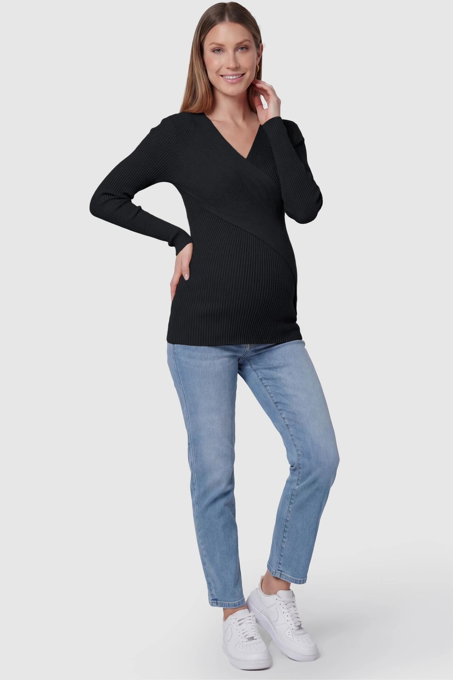 Cross-Over Ribbed Knit Maternity & Nursing Top Cross-Over Ribbed Knit Maternity & Nursing Top in Black featuring a wrap neckline and textured finish on a pregnant model, full body shot.