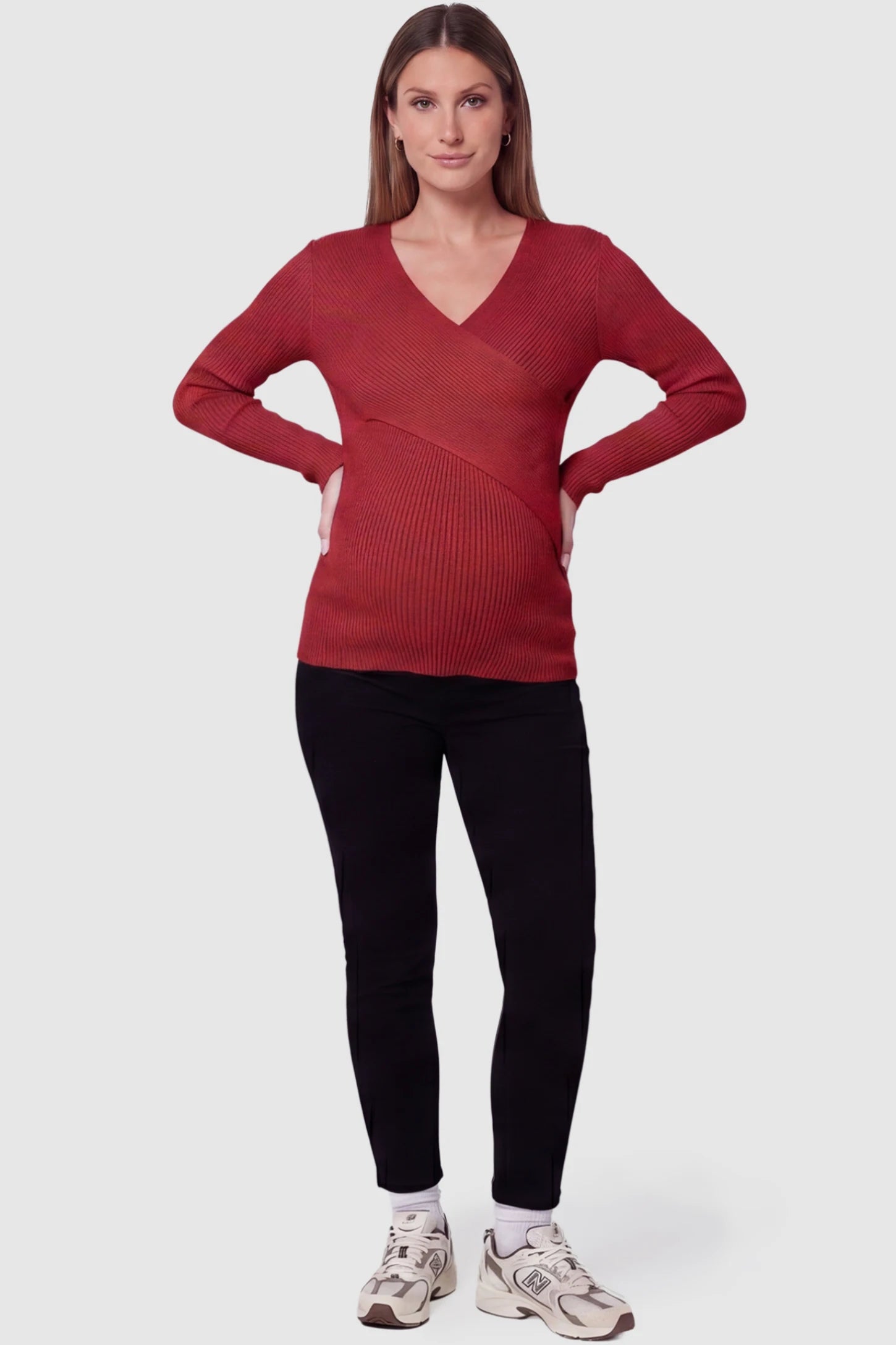 Cross-Over Ribbed Knit Maternity & Nursing Top Cross-Over Ribbed Knit Maternity & Nursing Top in Red featuring a wrap neckline and textured finish on a pregnant model, full body view.