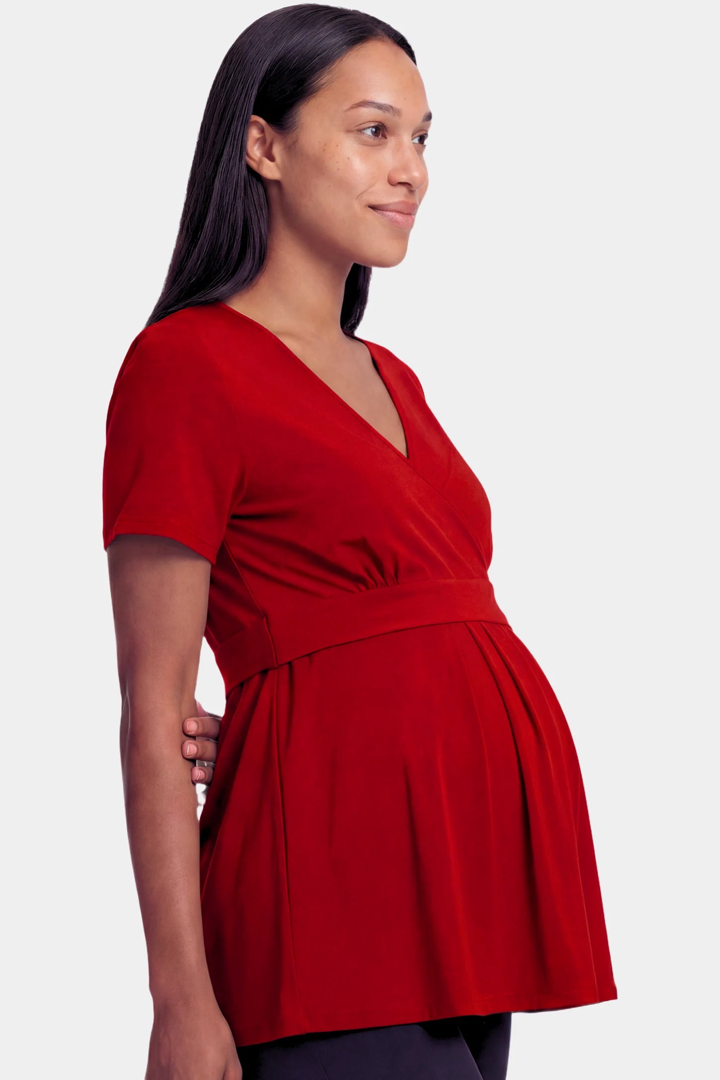 Crossover Short Sleeve Maternity & Nursing Top in burgundy featuring a crossover V-neck and empire waist on a pregnant model.