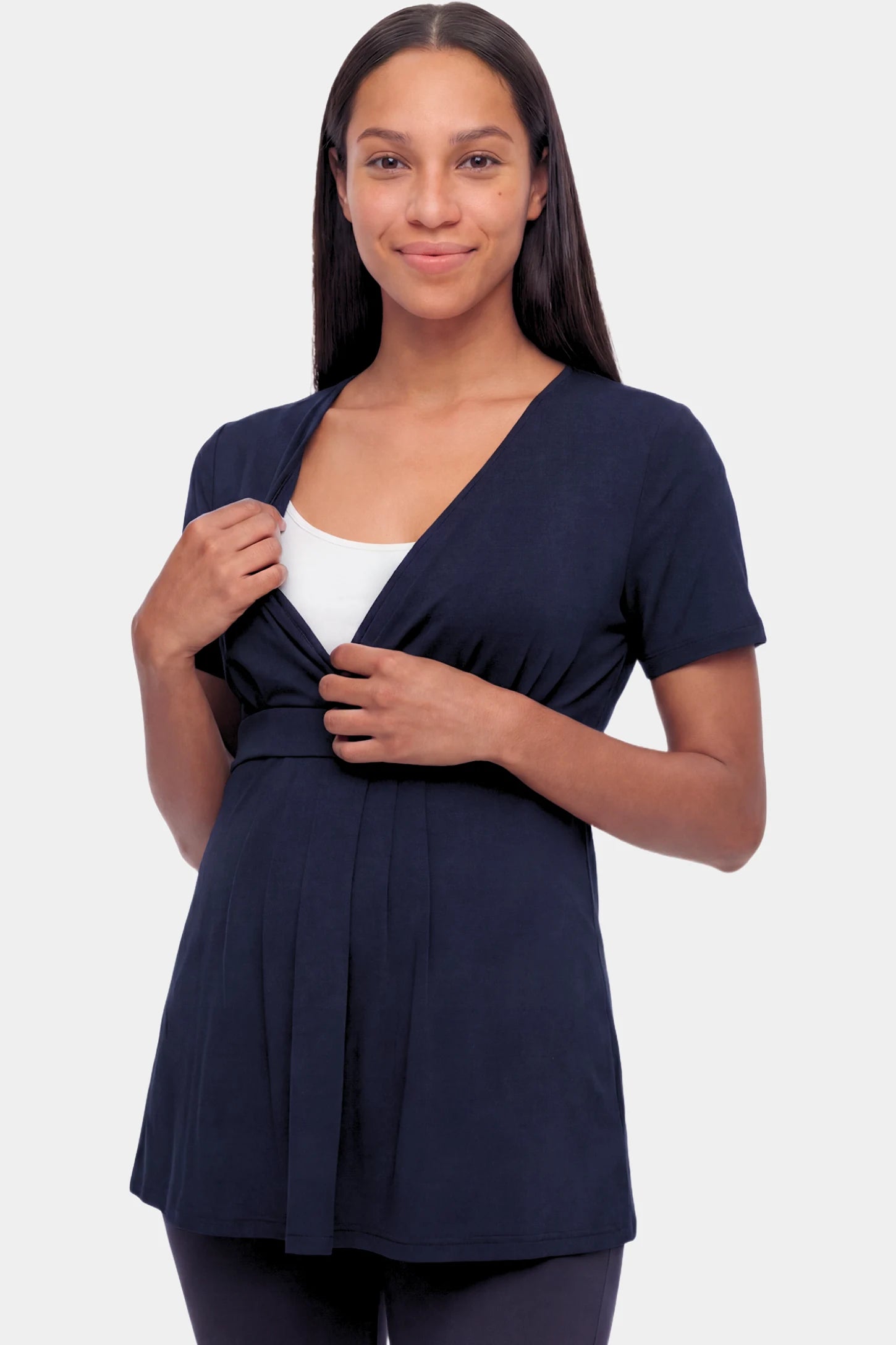 Crossover Short Sleeve Maternity & Nursing Top Crossover Short Sleeve Maternity & Nursing Top in dark blue featuring a crossover V-neck and empire waist on a pregnant model.