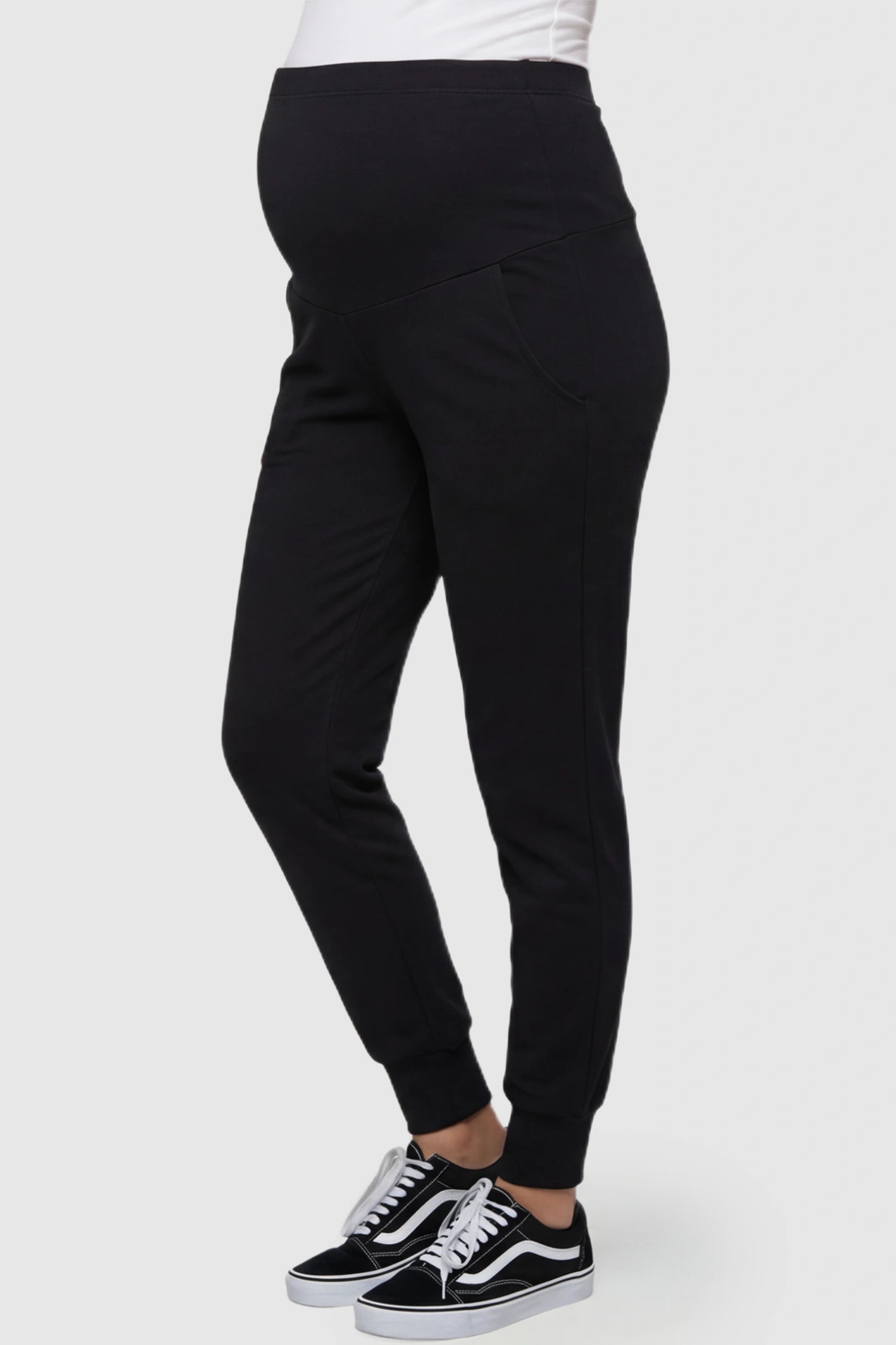 High-Rise Cuffed Maternity Joggers High-Rise Cuffed Maternity Joggers in black featuring over-the-belly support and ribbed cuff hem on pregnant model side view.