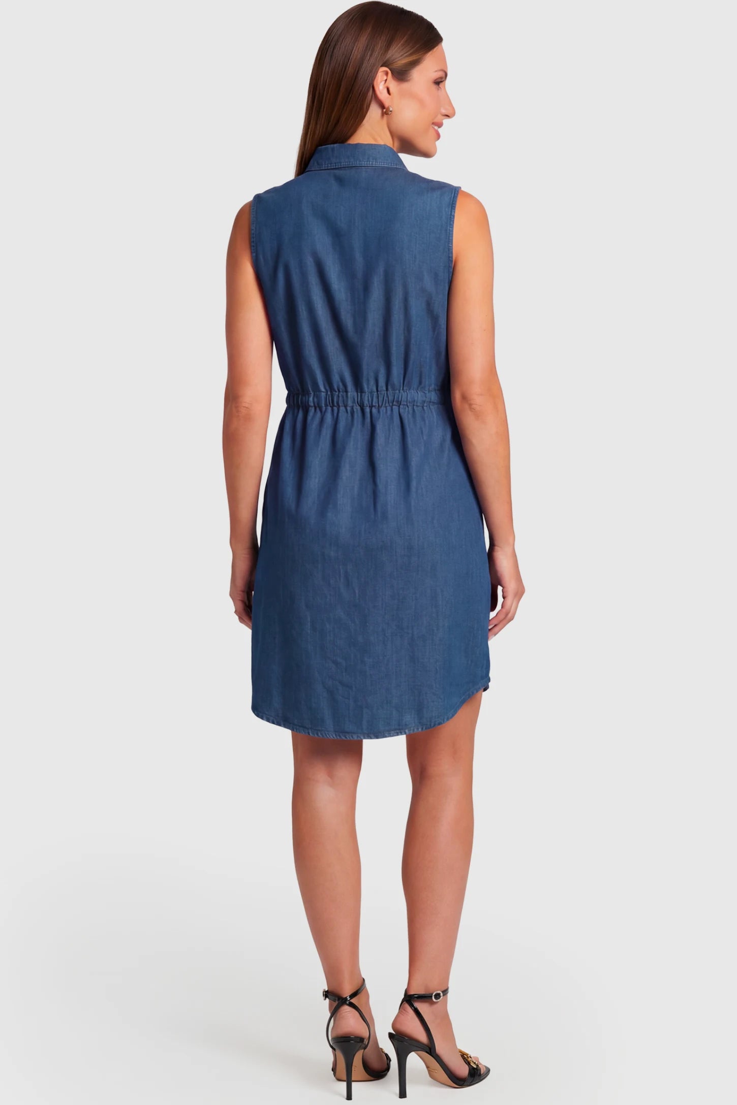 Denim Sleeveless Maternity & Nursing Midi Shirt Dress Denim Sleeveless Maternity & Nursing Midi Shirt Dress in dark blue featuring stand collar, and adjustable drawstring waist on a pregnant model.