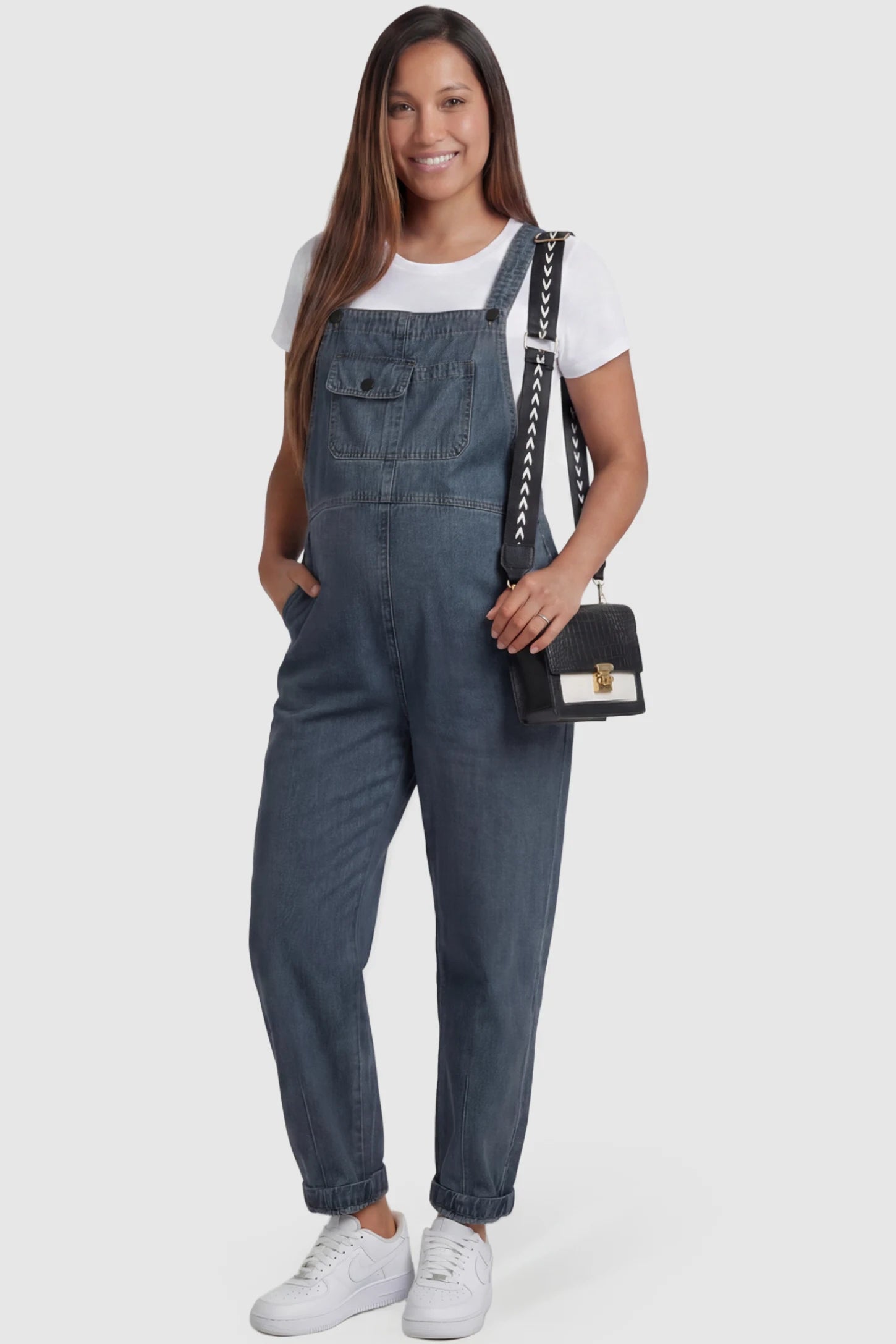 Wide Leg Denim Maternity Overalls in blue with adjustable straps and relaxed fit on pregnant model front view.