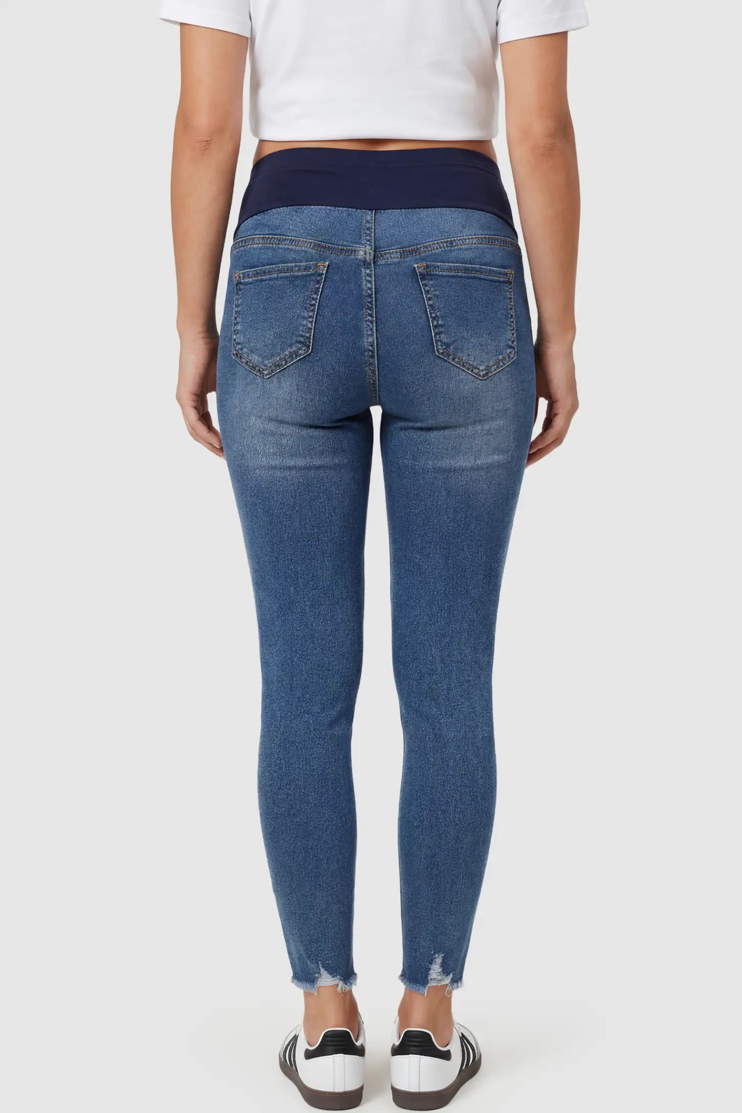 High-Rise Distressed Skinny Maternity Jeans High-Rise Distressed Skinny Maternity Jeans in navy blue featuring over-the-belly support panel and frayed hem on a pregnant model.