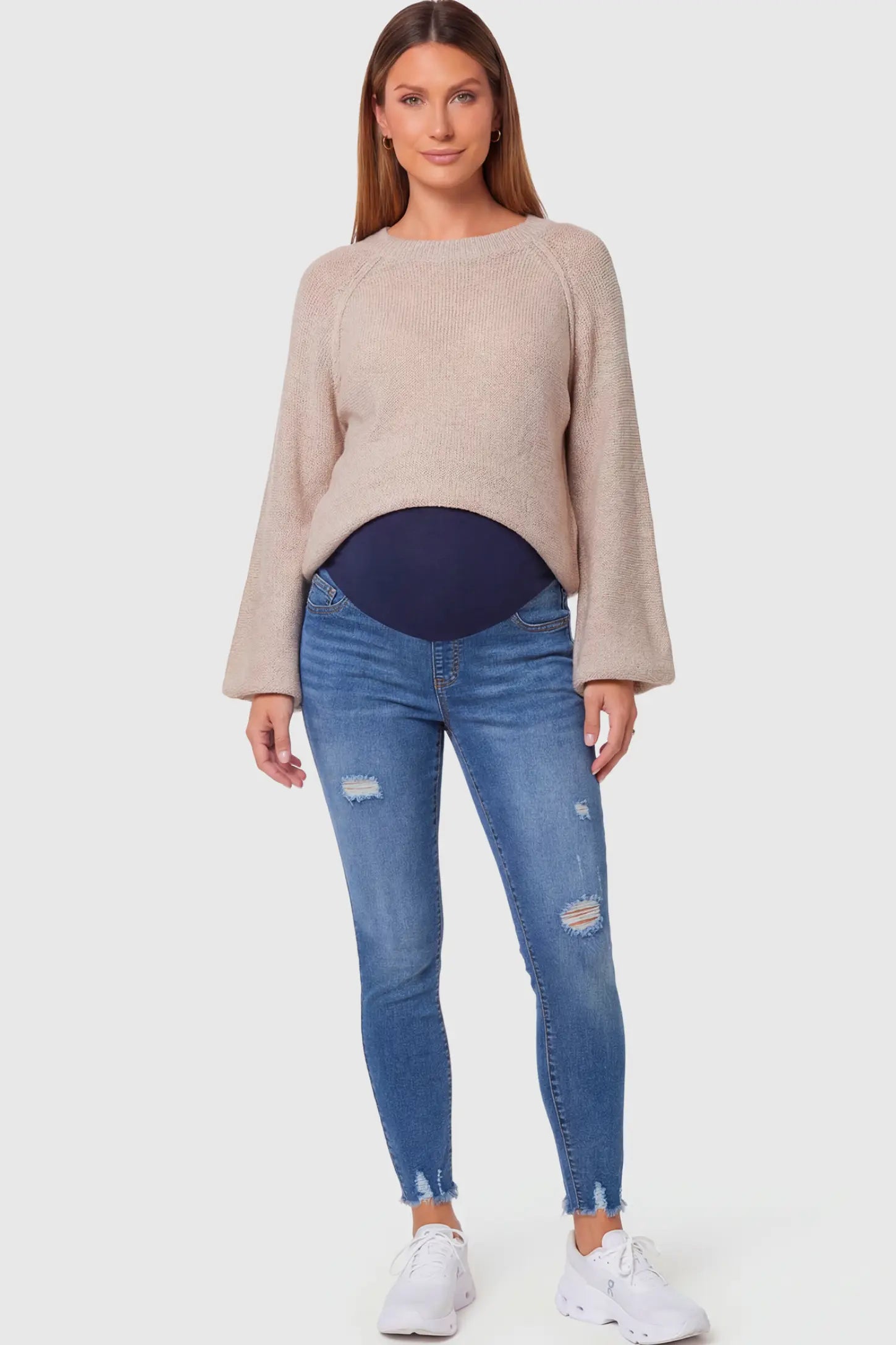High-Rise Distressed Skinny Maternity Jeans High-Rise Distressed Skinny Maternity Jeans in navy blue featuring over-the-belly support panel and frayed hem on a pregnant model.