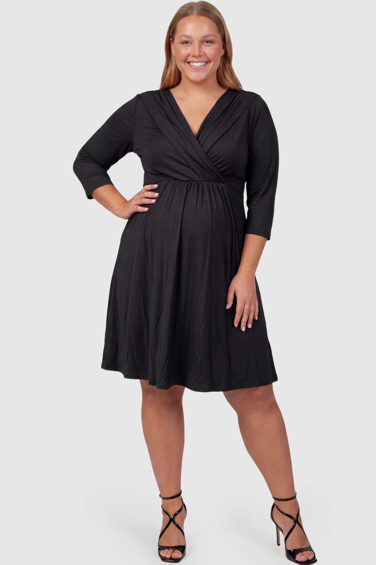 Crossover A-Line Maternity & Nursing Midi Dress Crossover A-line maternity & nursing midi dress in black with wrap-style V-neck bodice, front view on plus-size model