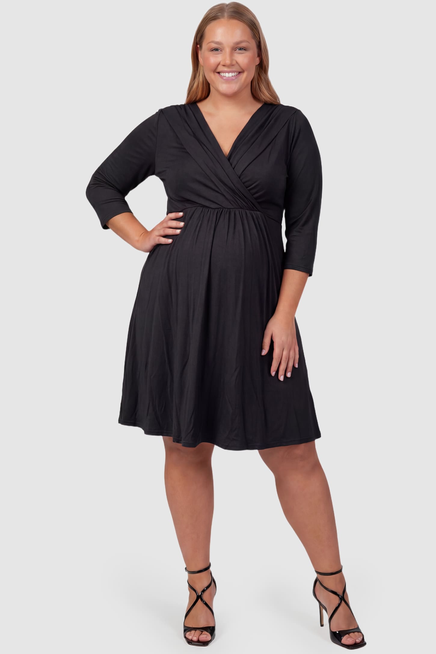 Crossover A-Line Maternity & Nursing Midi Dress Crossover A-Line Maternity & Nursing Midi Dress in black featuring wrap V-neck bodice and flowy midi skirt on plus size pregnant model.