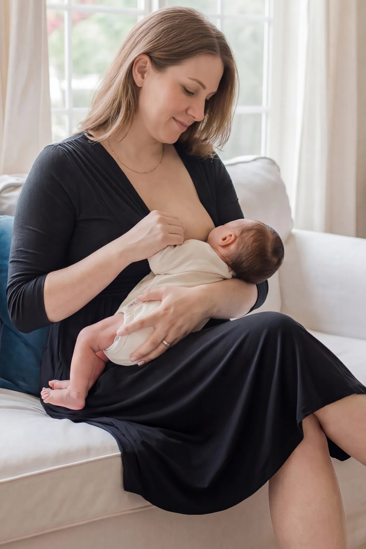 Crossover A-Line Maternity & Nursing Midi Dress Crossover A-line maternity & nursing midi dress in black with easy nursing access, side view on postpartum model