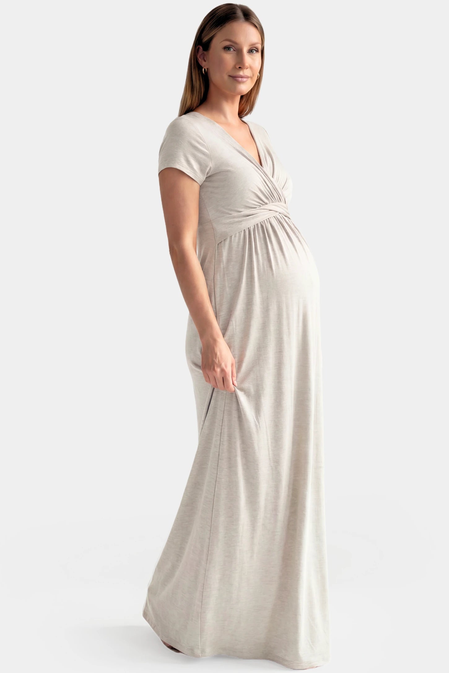 Crossover Draped Maternity & Nursing Maxi Dress Crossover Draped Maternity & Nursing Maxi Dress in light gray featuring a V-neck crossover design and flowy empire waist silhouette on a pregnant model.