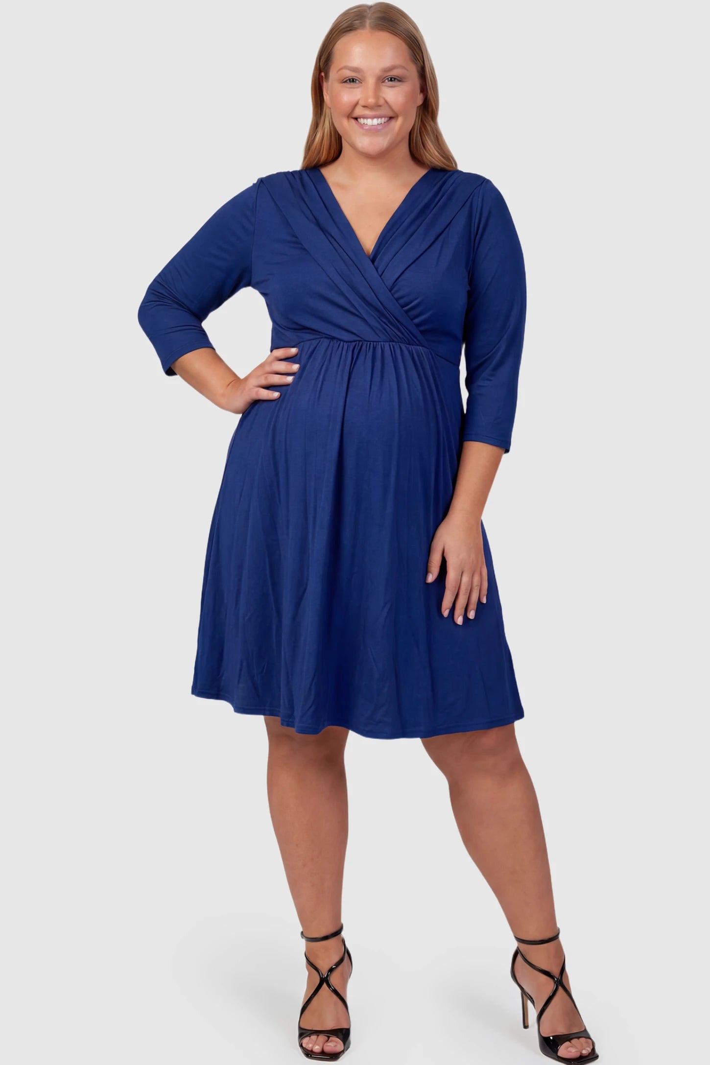 Crossover A-Line Maternity & Nursing Midi Dress Crossover A-line maternity & nursing midi dress in navy blue with wrap-style V-neck bodice, front view on plus-size model