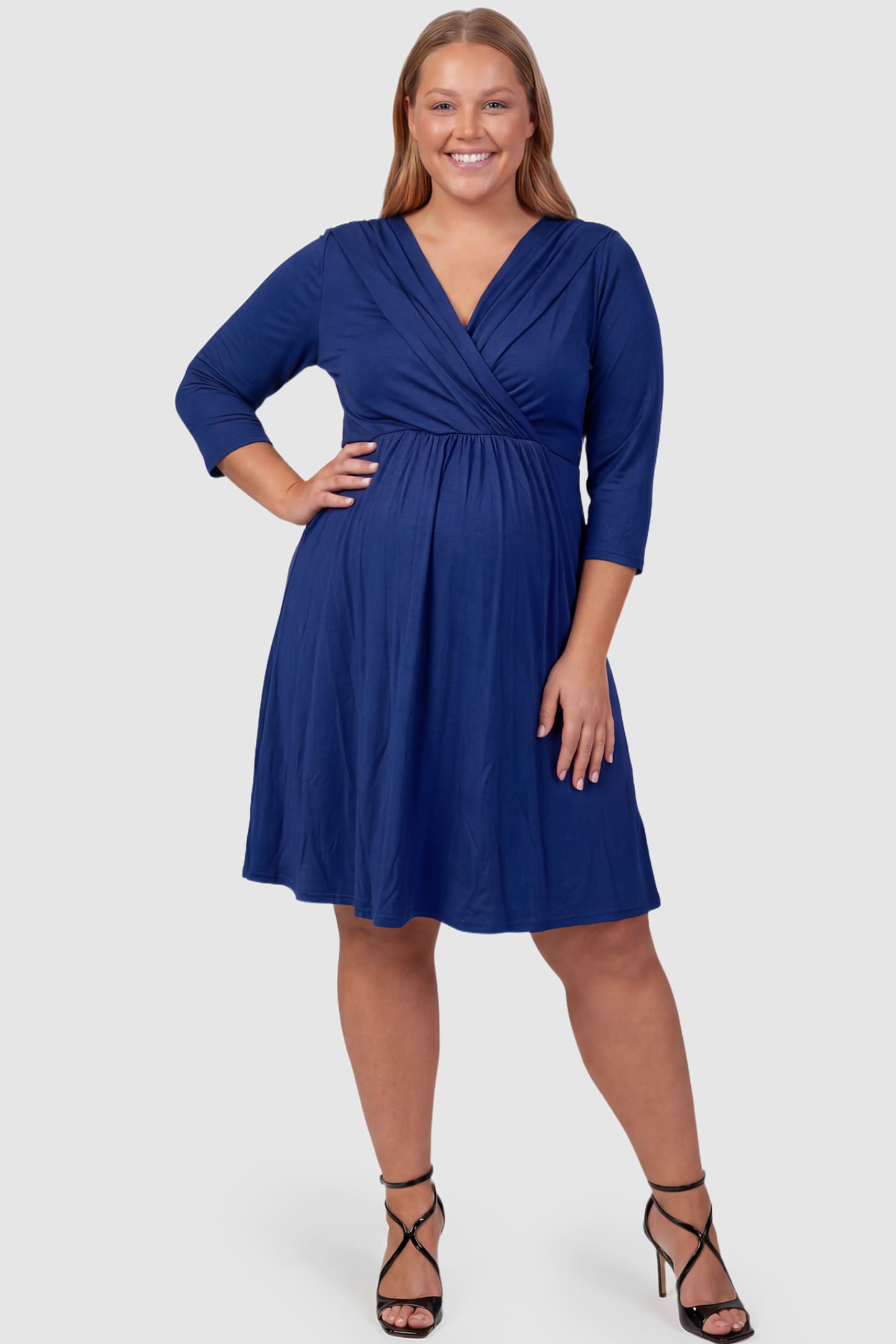 Crossover A-Line Maternity & Nursing Midi Dress Crossover A-Line Maternity & Nursing Midi Dress in navy blue featuring wrap V-neck bodice and flowy midi skirt on plus size pregnant model.