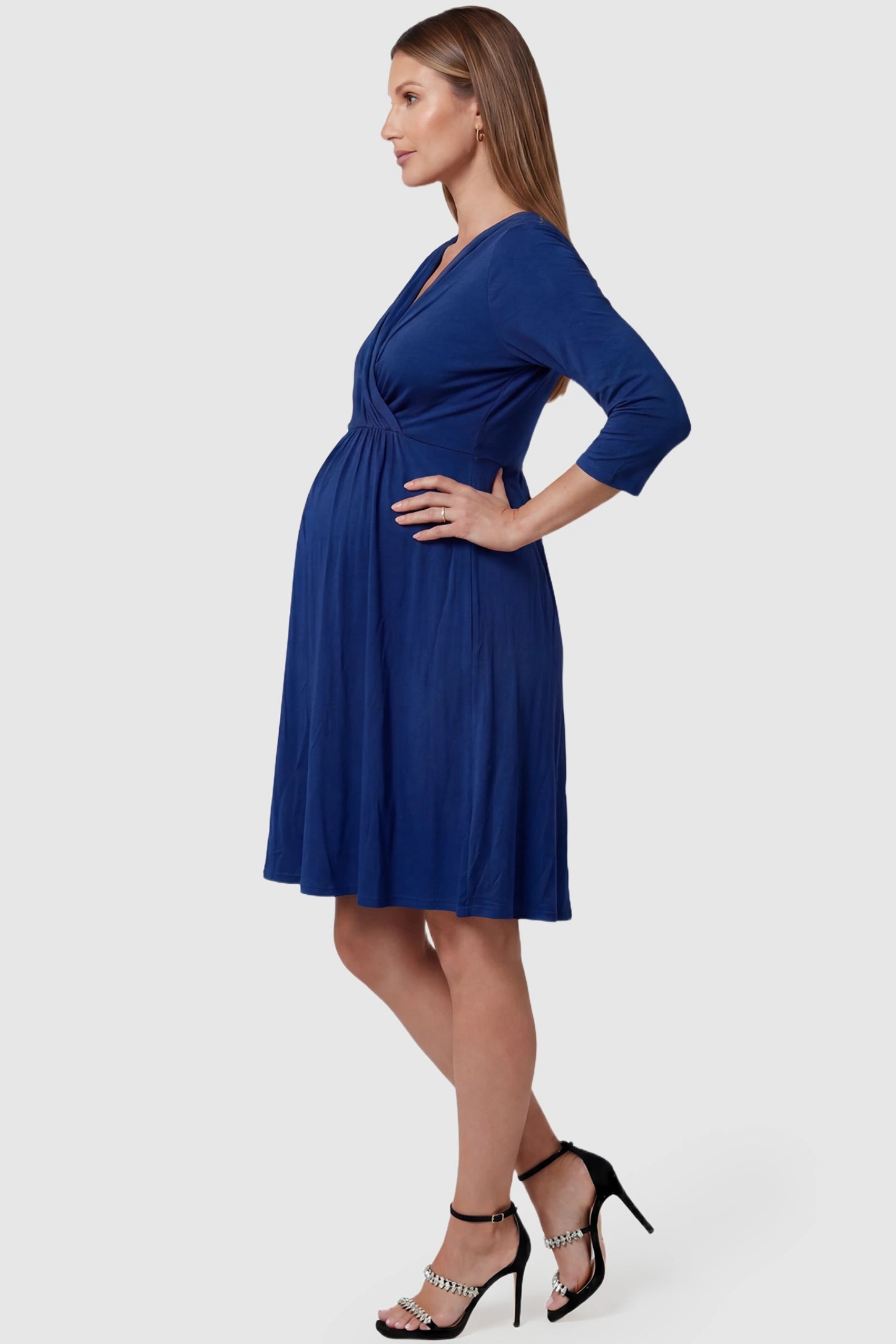 Crossover A-Line Maternity & Nursing Midi Dress Crossover A-line maternity & nursing midi dress in navy blue with bump-flattering empire waist, side view on pregnant model