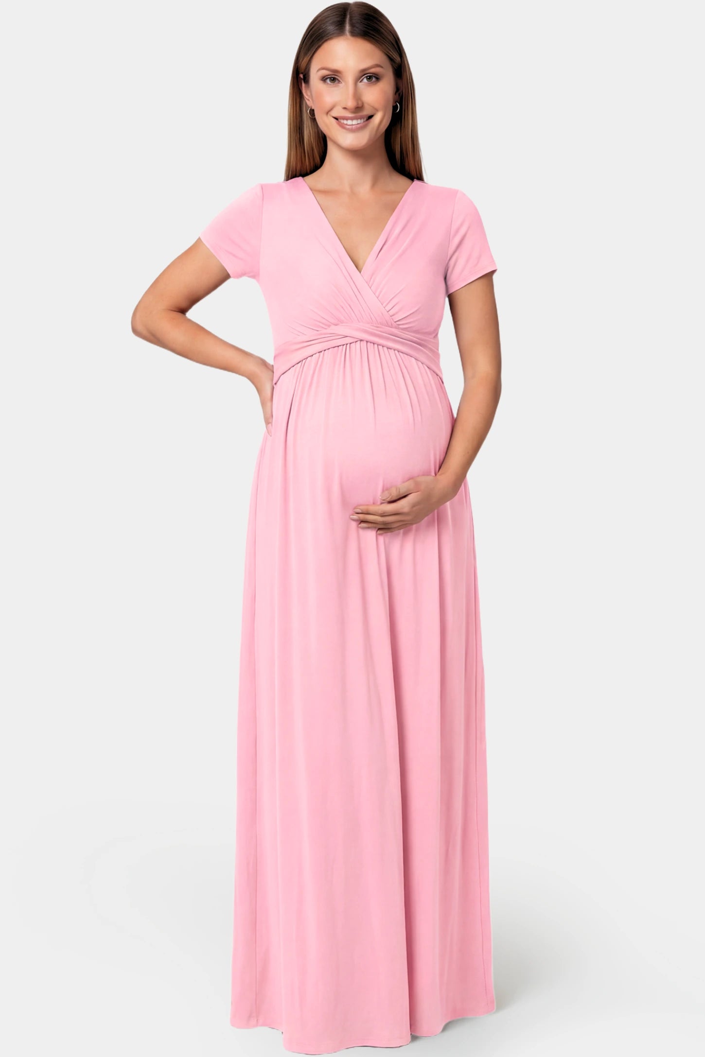 Crossover Draped Maternity & Nursing Maxi Dress Crossover Draped Maternity & Nursing Maxi Dress in pink featuring a V-neck crossover design and flowy empire waist silhouette on a pregnant model.