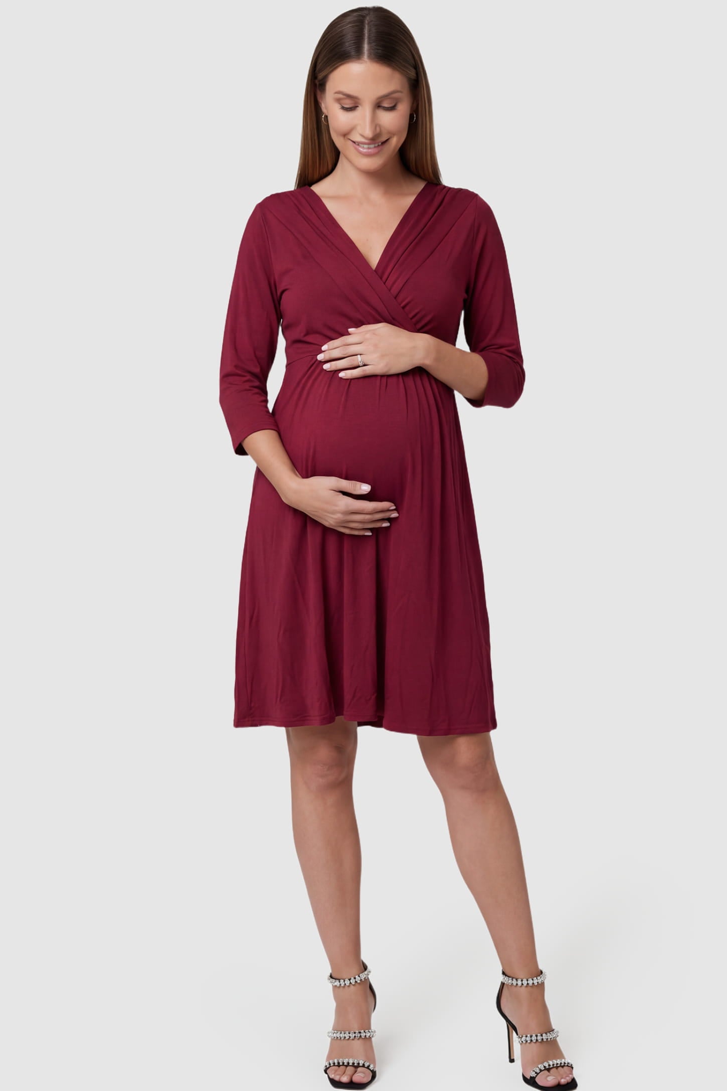 Crossover A-Line Maternity & Nursing Midi Dress Crossover A-Line Maternity & Nursing Midi Dress in red featuring wrap V-neck bodice and flowy midi skirt on pregnant model.