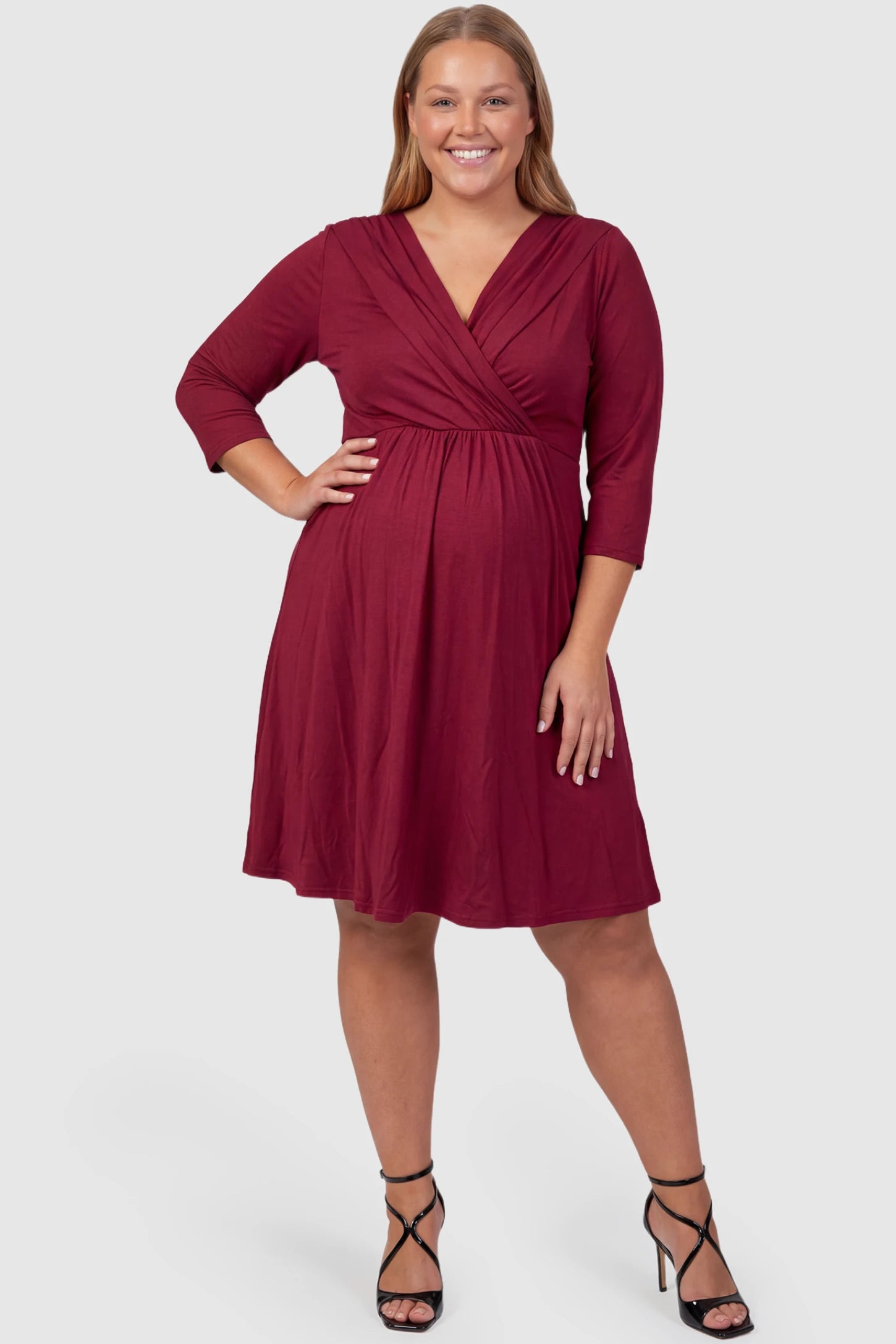 Crossover A-Line Maternity & Nursing Midi Dress Crossover A-line maternity & nursing midi dress in red with wrap-style V-neck bodice, front view on plus-size model