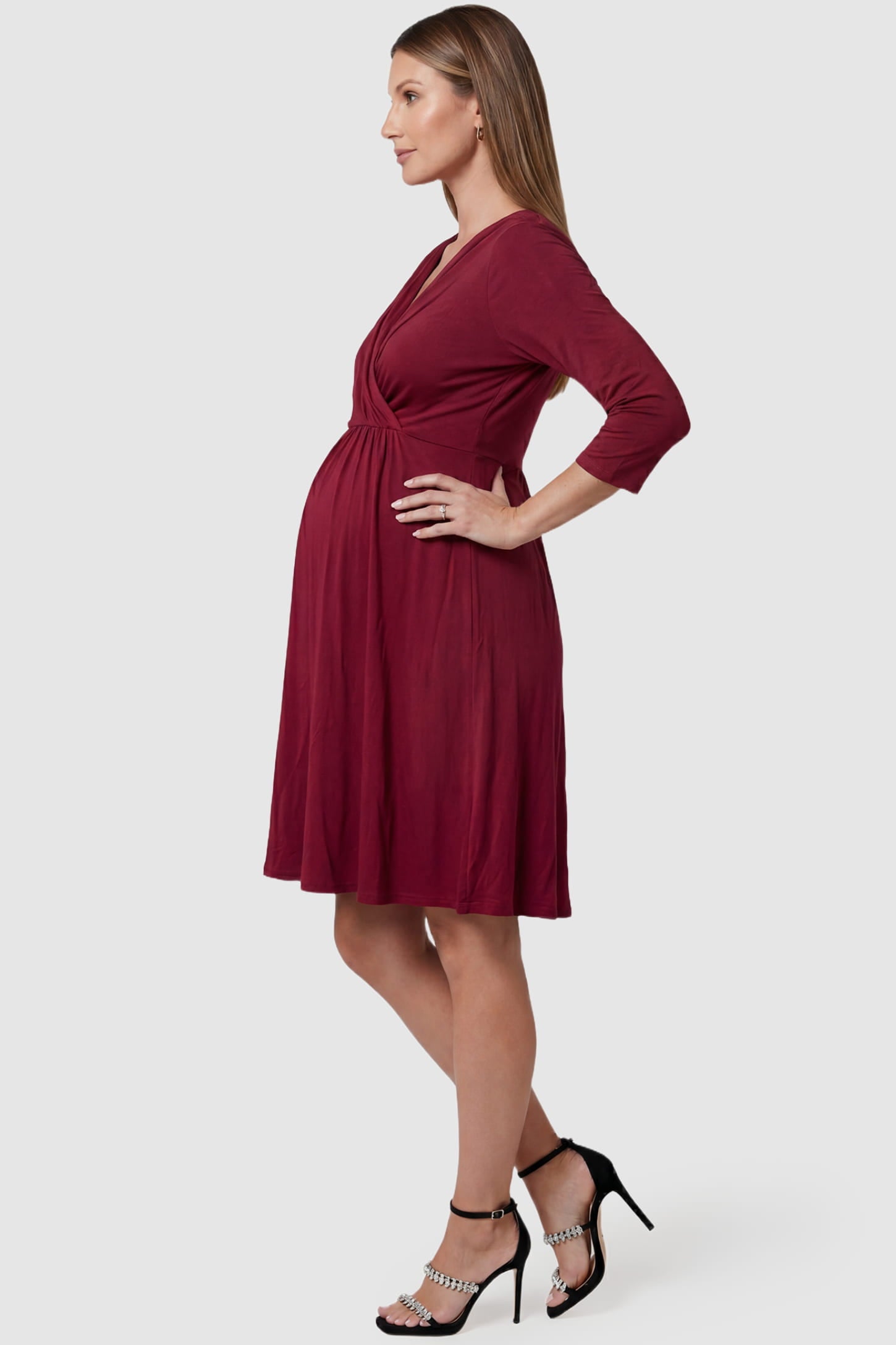 Crossover A-Line Maternity & Nursing Midi Dress Crossover A-Line Maternity & Nursing Midi Dress in red featuring wrap V-neck bodice and flowy midi skirt on pregnant model.