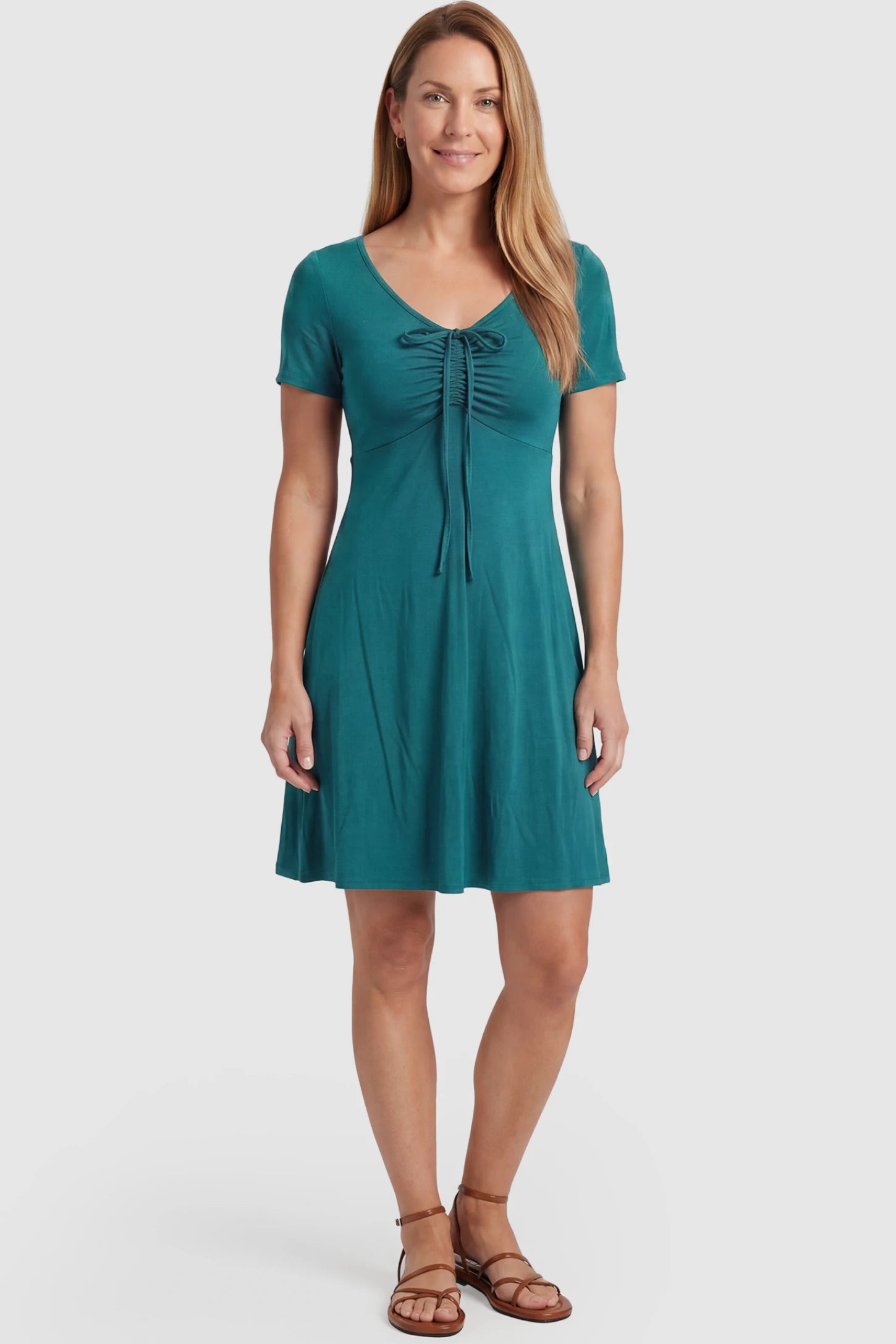 Drawstring Bow Front A‑Line Maternity Short Dress Drawstring bow front A-line maternity short dress in teal green with V-neckline and bow-tie front detail, front view on postpartum model