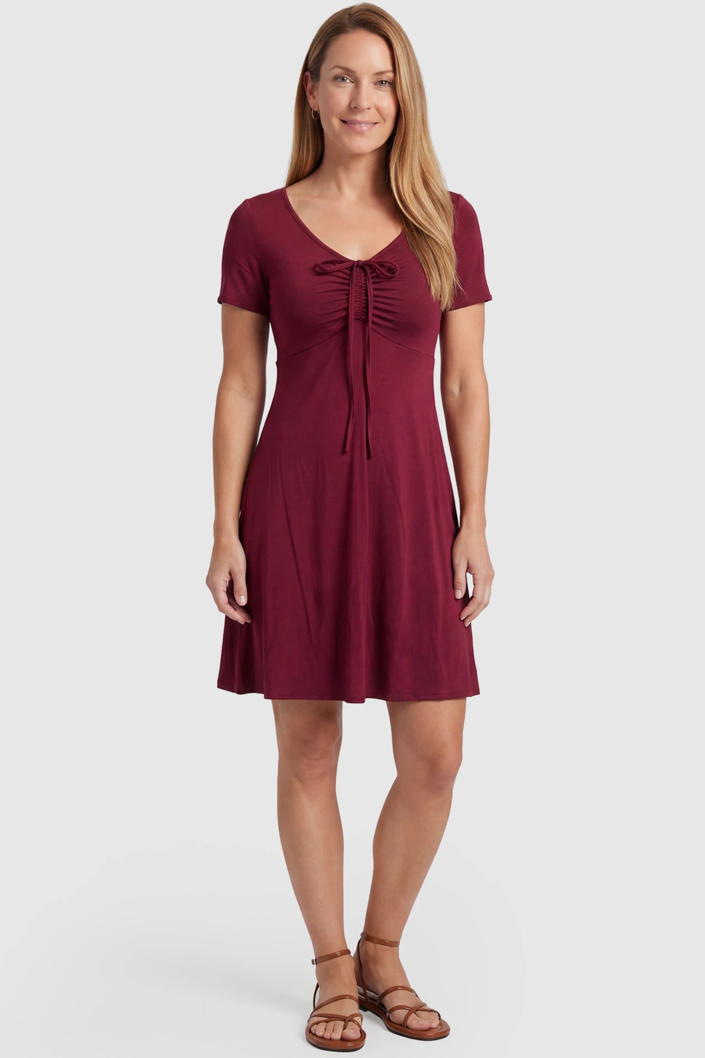 Drawstring Bow Front A‑Line Maternity Short Dress Drawstring bow front A-line maternity short dress in wine red with V-neckline and bow-tie front detail, front view on postpartum model