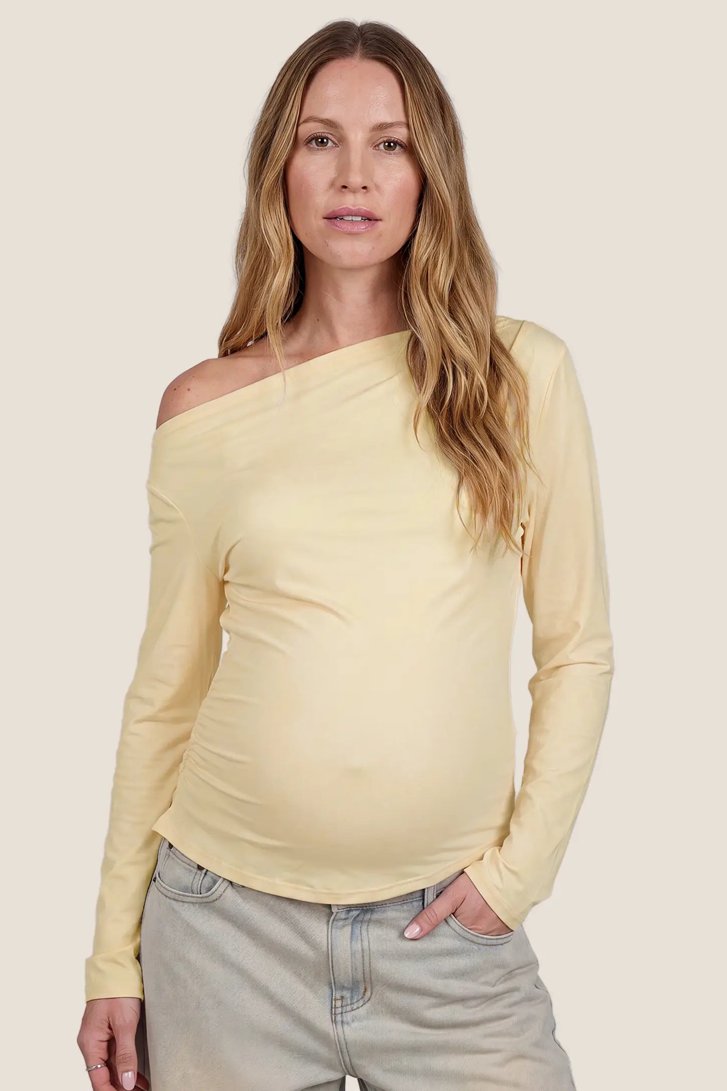 Elegant Ruched Side Off-Shoulder Maternity Top in Butter Yellow featuring off-the-shoulder neckline, flattering ruched sides, stretchy fit, and body-hugging silhouette on a pregnant model, front view.