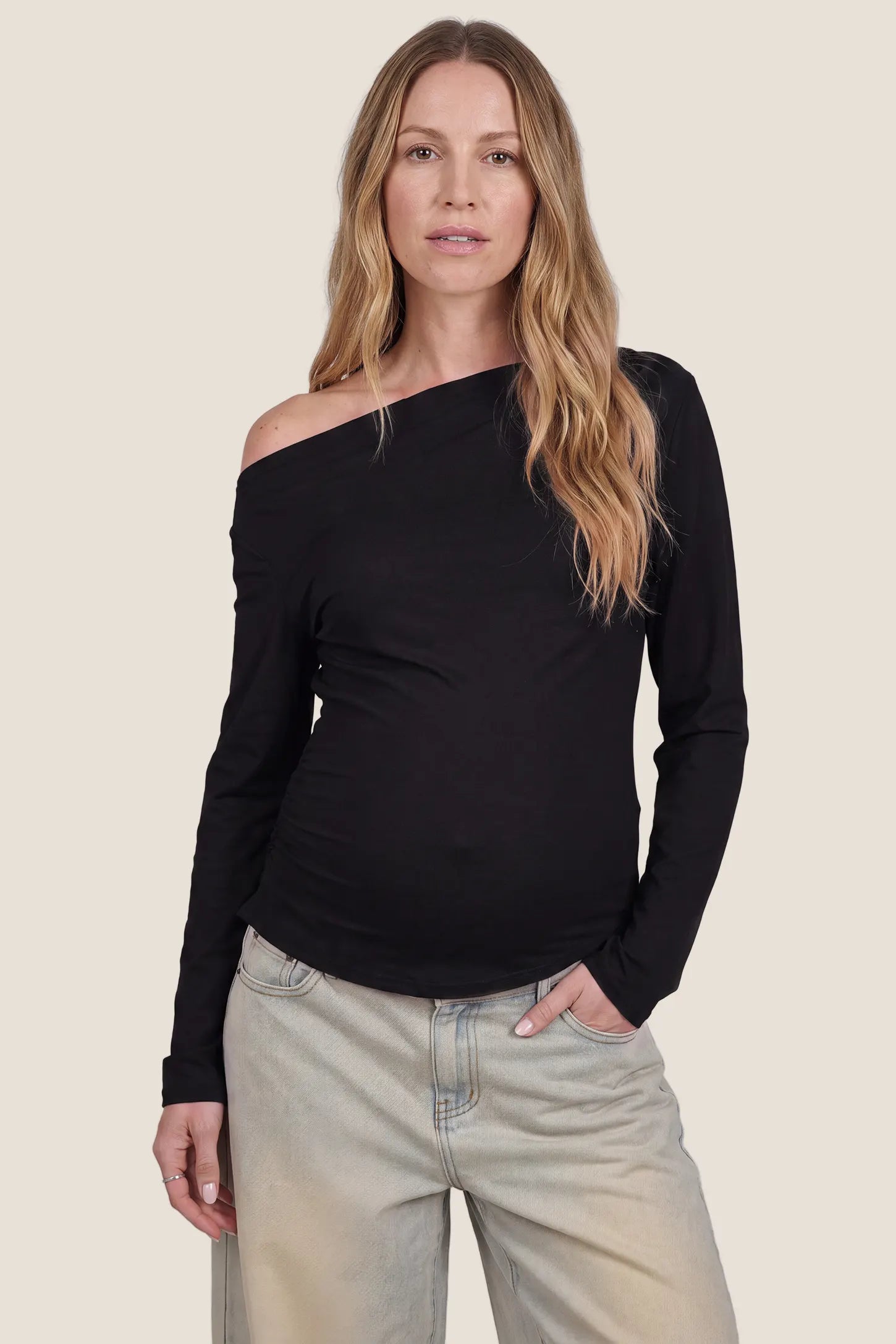 Elegant Black Ruched Side Off-Shoulder Maternity Top Elegant Ruched Side Off-Shoulder Maternity Top in Black featuring an off-shoulder neckline, ruched side details, soft smooth lightweight fabric, stretchy fit, and a body-hugging silhouette for comfortable everyday wear on a pregnant model, front view.