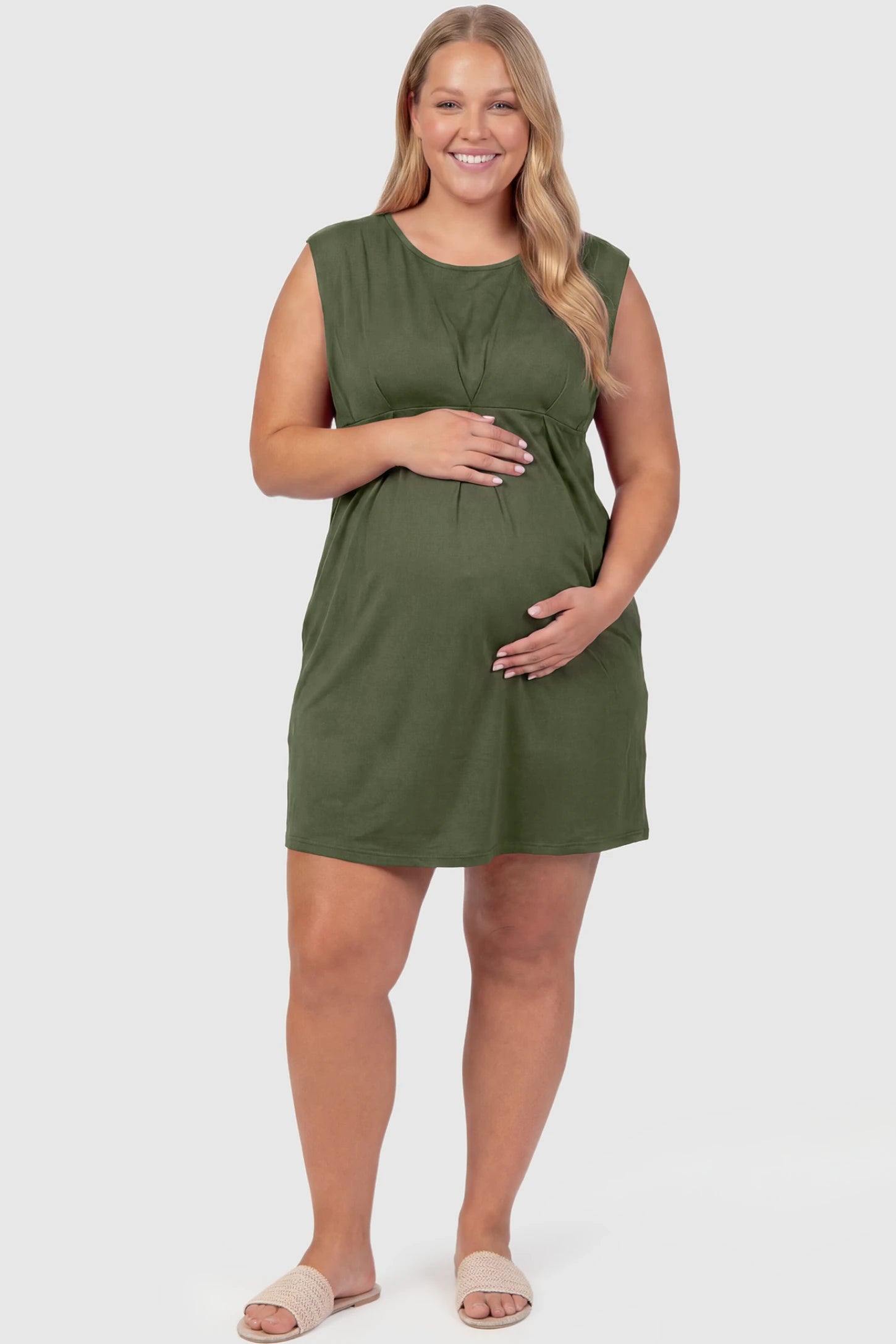Sleeveless Empire Waist Maternity Short Dress Sleeveless empire waist maternity short dress in army green with short length and sleeveless design, front view on plus-size model