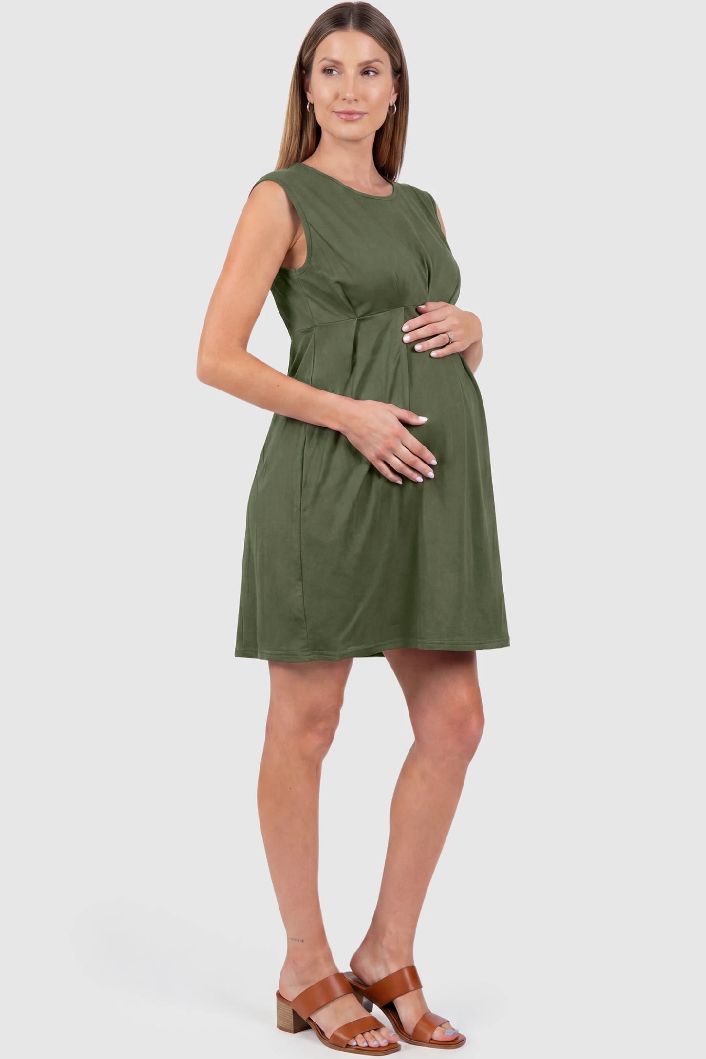 Sleeveless Empire Waist Maternity Short Dress Sleeveless empire waist maternity short dress in army green with short length and sleeveless design, side view on pregnant model